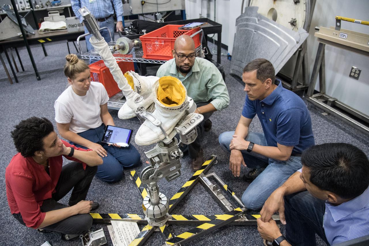 jsc2018e049894 (05-18-18) ---(From left) 2017 NASA astronaut candidate Jessica Watkins, Canadian Space Agency astronaut candidate Jennifer Sidey-Gibbons, and NASA astronaut candidates Bob Hines and Frank Rubio are instructed on International Space Station tools associated with their spacesuits at NASA Johnson Space Center’s Neutral Buoyancy Laboratory in Houston. Photo Credit: (NASA/James Blair)