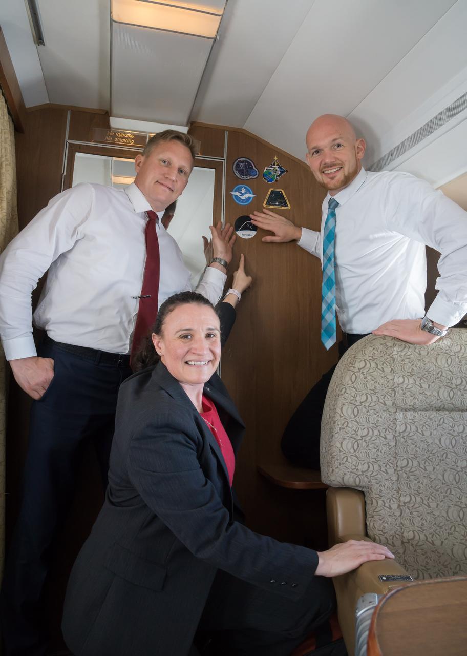 jsc2018e049985 - Aboard a Gagarin Cosmonaut Training Center aircraft, Expedition 56 crewmembers Sergey Prokopyev of Roscosmos (left), Serena Aunon-Chancellor of NASA (center) and Alexander Gerst of the European Space Agency (right) affix crew insignia decals to the cabin wall May 19 as they flew from their Russian training base to their launch site at the Baikonur Cosmodrome in Kazakhstan. They will launch June 6 on the Soyuz MS-09 spacecraft from the Baikonur Cosmodrome for a six-month mission on the International Space Station...NASA/Victor Zelentsov.