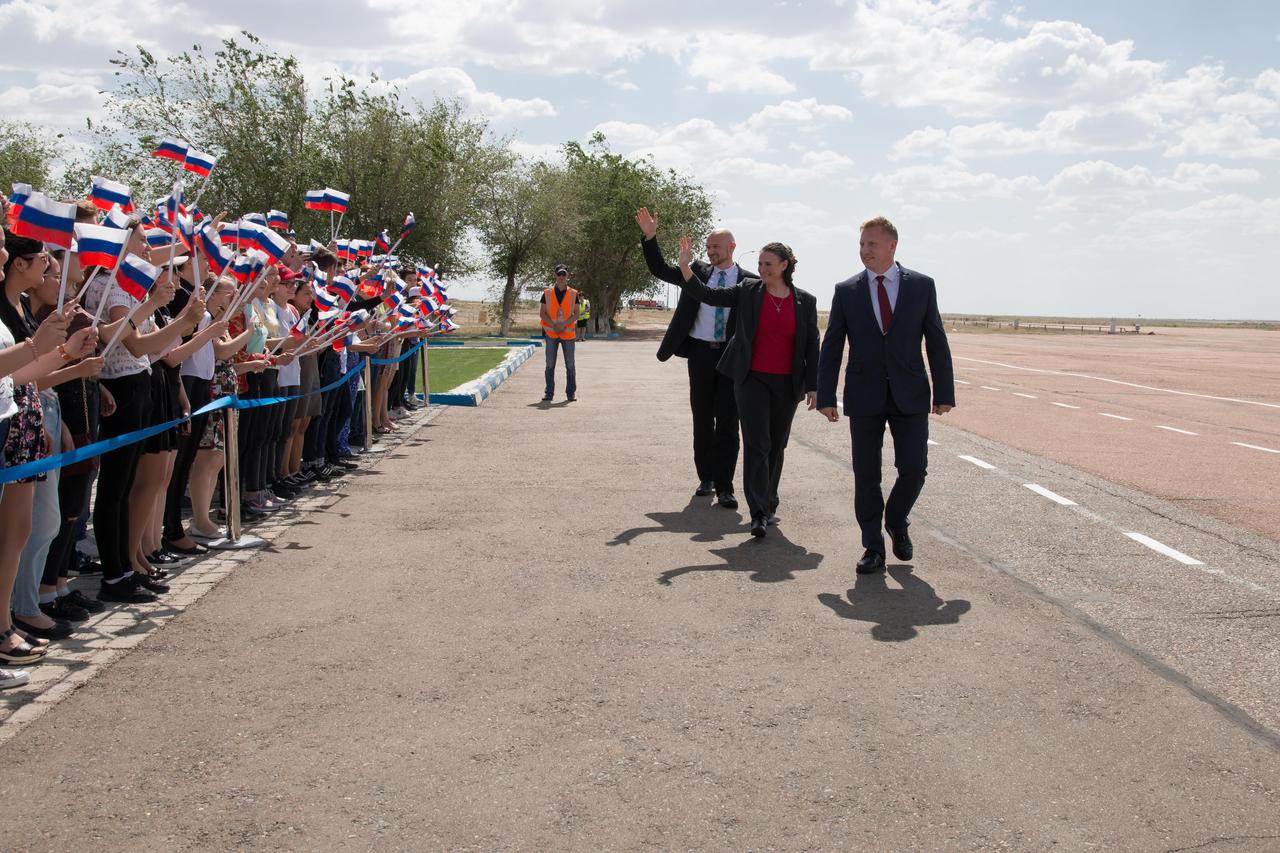 jsc2018e049988 - Expedition 56 crewmembers Alexander Gerst of the European Space Agency (top right), Serena Aunon-Chancellor of NASA (center) and Sergey Prokopyev of Roscosmos wave to a throng of schoolchildren May 19 upon their arrival at their launch site at the Baikonur Cosmodrome in Kazakhstan. They will launch June 6 on the Soyuz MS-09 spacecraft from the Baikonur Cosmodrome for a six-month mission on the International Space Station...NASA/Victor Zelentsov.