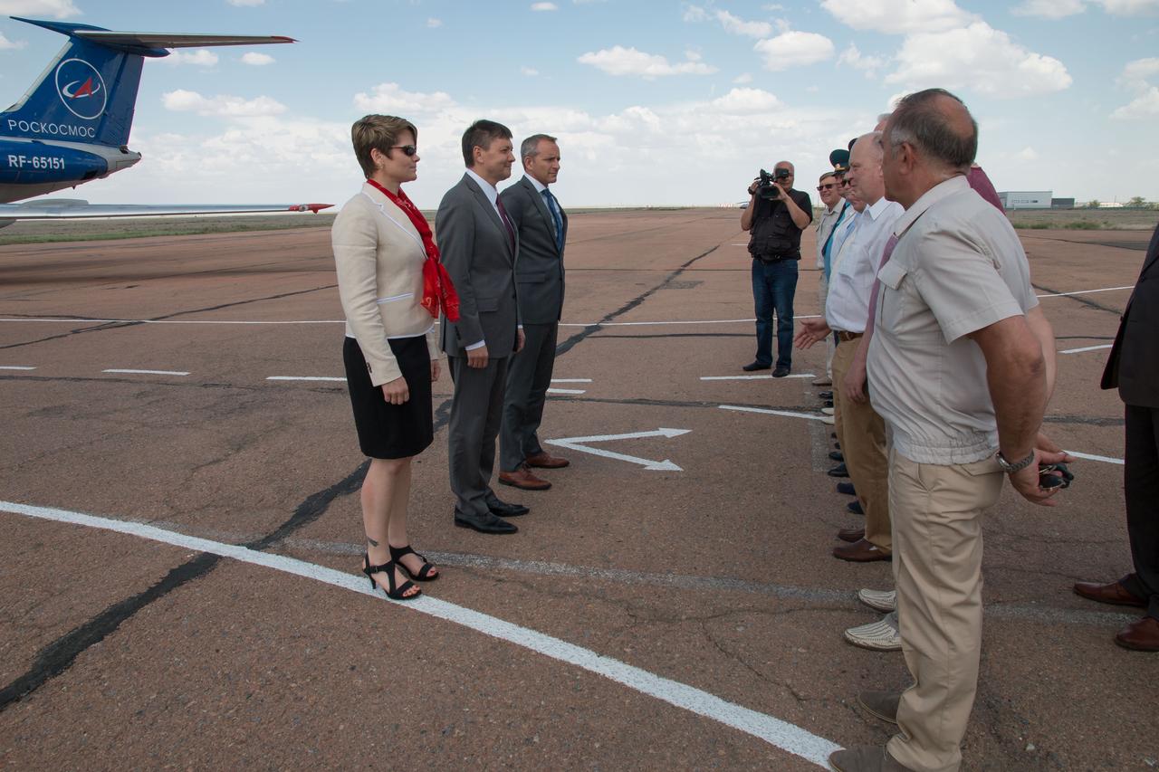 jsc2018e049990 -Expedition 56 backup crewmembers Anne McClain of NASA (left), Oleg Kononenko of Roscosmos (center) and David Saint-Jacques of the Canadian Space Agency are greeted by Russian space officials May 19 after arriving at the launch site at the Baikonur Cosmodrome in Kazakhstan for final training following a flight from their training base in Star City, Russia. They are the backups to Serena Aunon-Chancellor of NASA, Sergey Prokopyev of Roscosmos and Alexander Gerst of the European Space Agency who will launch June 6 on the Soyuz MS-09 spacecraft from the Baikonur Cosmodrome for a six-month mission on the International Space Station...NASA/Victor Zelentsov.