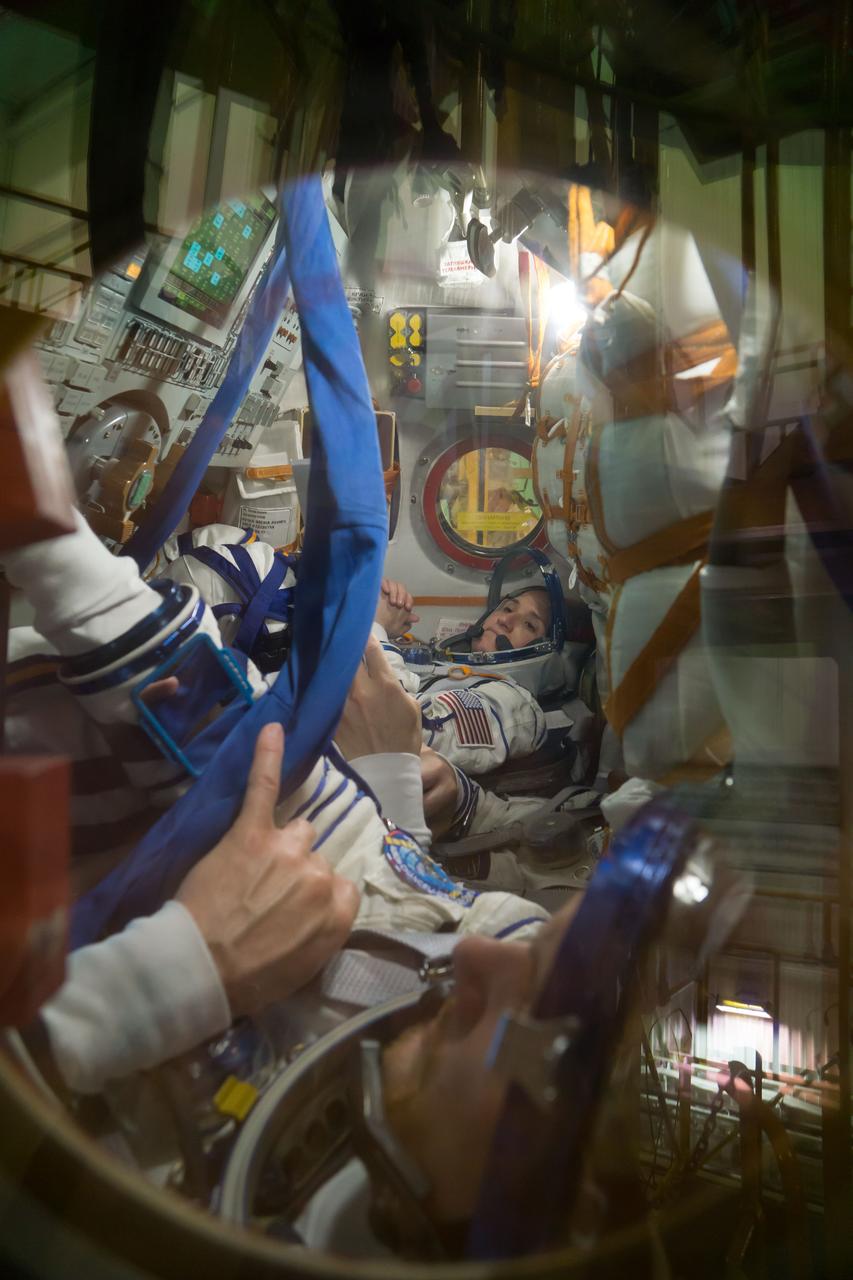 jsc2018e050007 - In the Integration Facility at the Baikonur Cosmodrome in Kazakhstan, Expedition 56 crewmember Serena Aunon-Chancellor of NASA runs through procedures May 20 in the Soyuz MS-09 spacecraft as part of the first fit check dress rehearsal activities. Aunon-Chancellor, Sergey Prokopyev of Roscosmos and Alexander Gerst of the European Space Agency will launch June 6 on the Soyuz MS-09 spacecraft from Baikonur for a six-month mission on the International Space Station...NASA/Victor Zelentsov.