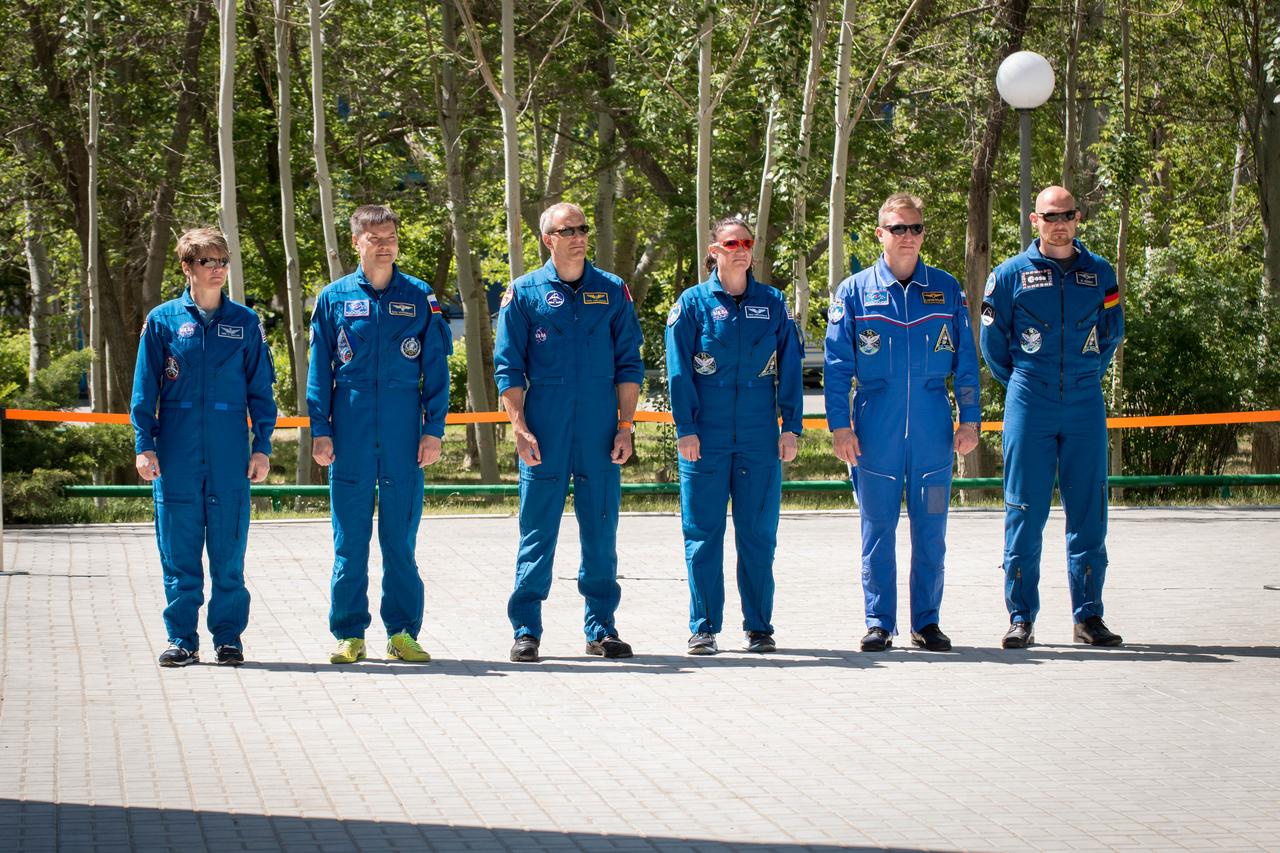 jsc2018e050013 - At their Cosmonaut Hotel crew quarters in Baikonur, Kazakhstan, the Expedition 56 prime and backup crewmembers attend traditional flag-raising ceremonies May 21 as part of their pre-launch activities. From left to right are backup crewmembers Anne McClain of NASA, Oleg Kononenko of Roscosmos and David Saint-Jacques of the Canadian Space Agency and prime crewmembers Serena Aunon-Chancellor of NASA, Sergey Prokopyev of Roscosmos and Alexander Gerst of the European Space Agency. Aunon-Chancellor, Prokopyev and Gerst will launch June 6 on the Soyuz MS-09 spacecraft from Baikonur for a six-month mission on the International Space Station...NASA/Victor Zelentsov.
