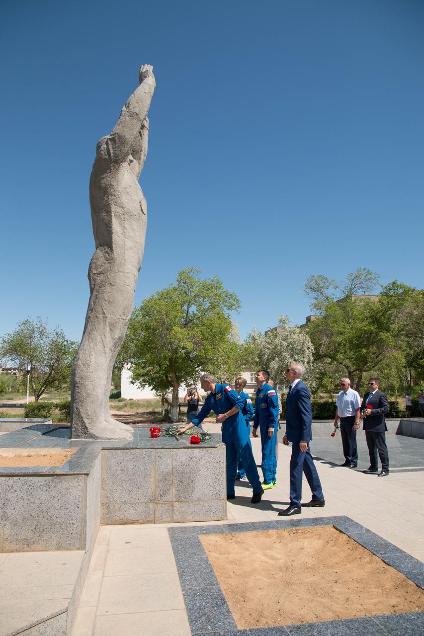 jsc2018e050016 - In the town of Baikonur, Kazakhstan, Expedition 56 backup crewmember David Saint-Jacques of the Canadian Space Agency lays flowers at the statue of Yuri Gagarin, the first human to fly in space as his crewmates look on during traditional pre-launch activities May 21. Saint-Jacques, Anne McClain of NASA and Oleg Kononenko of Roscosmos are the backups to the prime crew, Serena Aunon-Chancellor of NASA, Sergey Prokopyev of Roscosmos and Alexander Gerst of the European Space Agency, who will launch June 6 on the Soyuz MS-09 spacecraft from Baikonur for a six-month mission on the International Space Station...NASA/Victor Zelentsov.