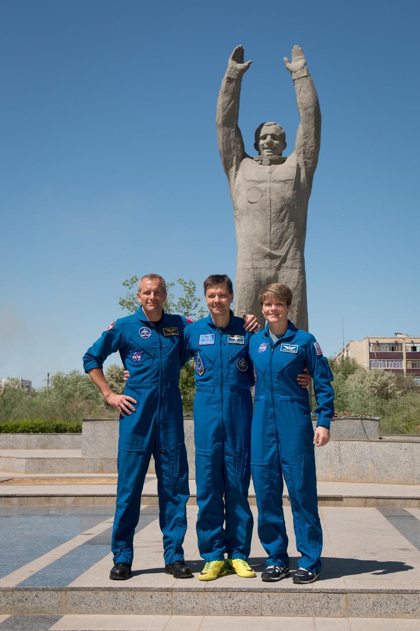 jsc2018e050017 - In the town of Baikonur, Kazakhstan, Expedition 56 backup crewmembers David Saint-Jacques of the Canadian Space Agency (left), Oleg Kononenko of Roscosmos (center) and Anne McClain of NASA (right) pose for pictures May 21 at the statue of Yuri Gagarin, the first human to fly in space during traditional pre-launch activities. They are the backups to the prime crew, Serena Aunon-Chancellor of NASA, Sergey Prokopyev of Roscosmos and Alexander Gerst of the European Space Agency, who will launch June 6 on the Soyuz MS-09 spacecraft from Baikonur for a six-month mission on the International Space Station...NASA/Victor Zelentsov.