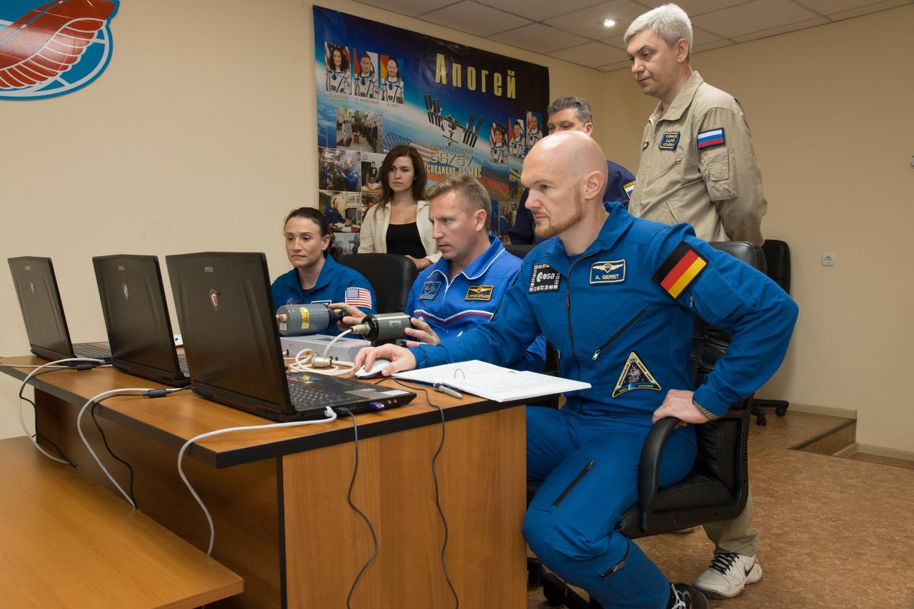 jsc2018e050821 - At the Cosmonaut Hotel crew quarters in Baikonur, Kazakhstan, Expedition 56 crewmembers Serena Aunon-Chancellor of NASA (left), Sergey Prokopyev of Roscosmos (center) and Alexander Gerst of the European Space Agency (right) conduct rendezvous and docking procedures on a laptop training simulator May 29 as part of their pre-launch preparations. Aunon-Chancellor, Prokopyev and Gerst will launch June 6 from the Baikonur Cosmodrome in Kazakhstan on the Soyuz MS-09 spacecraft for a six-month mission on the International Space Station...NASA/Victor Zelentsov.