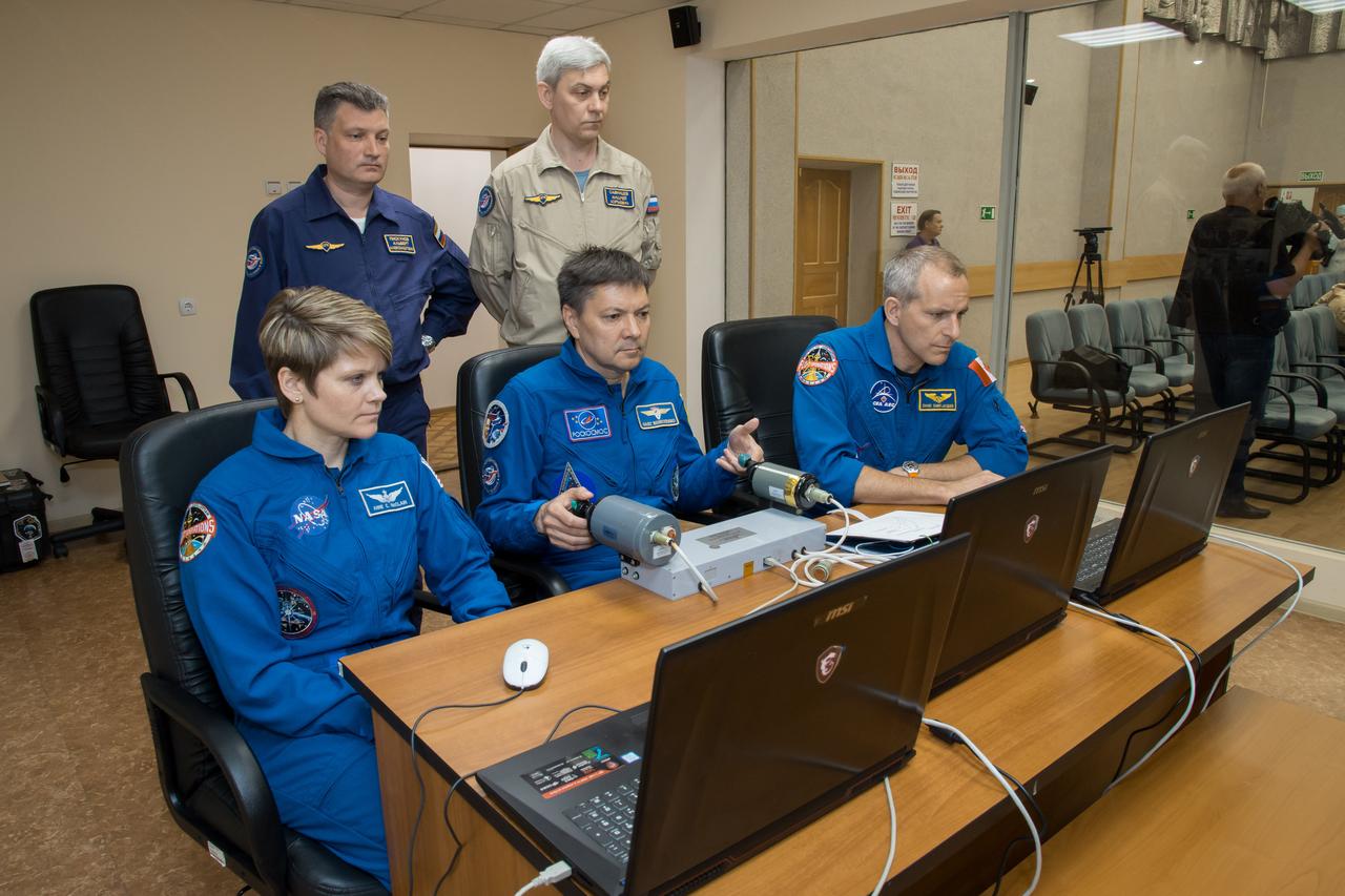 jsc2018e050822 - At the Cosmonaut Hotel crew quarters in Baikonur, Kazakhstan, Expedition 56 backup crewmembers Anne McClain of NASA (left), Oleg Kononenko of Roscosmos (center) and David Saint-Jacques of the Canadian Space Agency (right) conduct rendezvous and docking procedures on a laptop training simulator May 29 as part of their pre-launch preparations. They are serving as backups to the prime crew, Serena Aunon-Chancellor of NASA, Sergey Prokopyev of Roscosmos and Alexander Gerst of the European Space Agency, who will launch June 6 from the Baikonur Cosmodrome in Kazakhstan on the Soyuz MS-09 spacecraft for a six-month mission on the International Space Station..NASA/Victor Zelentsov