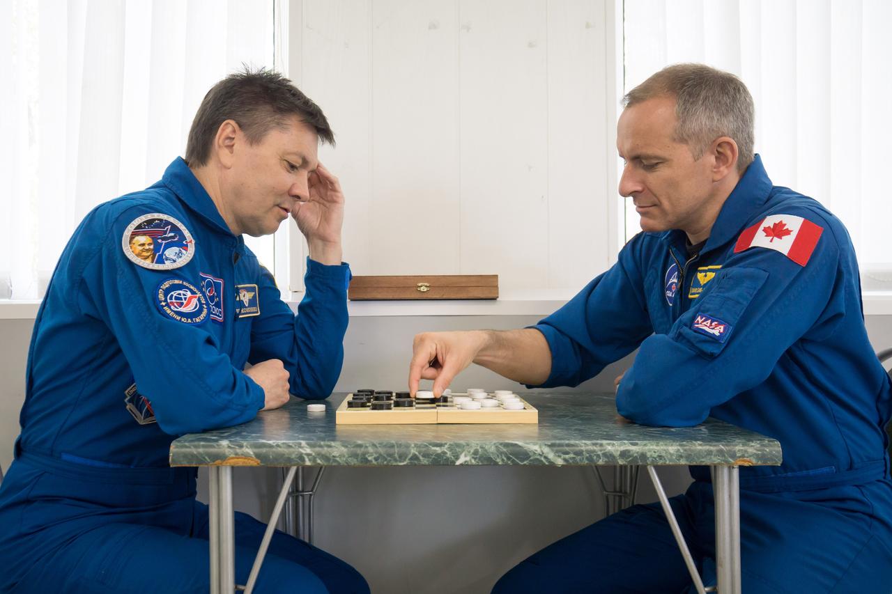 jsc2018e050826 - At the Cosmonaut Hotel crew quarters in Baikonur, Kazakhstan, Expedition 56 backup crewmembers Oleg Kononenko of Roscosmos (left) and David Saint-Jacques of the Canadian Space Agency try their hand at a game of chess May 29 as part of the traditional pre-launch ceremonies. They are two of the backups to the prime crew, Serena Aunon-Chancellor of NASA, Sergey Prokopyev of Roscosmos and Alexander Gerst of the European Space Agency, who will launch June 6 from the Baikonur Cosmodrome in Kazakhstan on the Soyuz MS-09 spacecraft for a six-month mission on the International Space Station...NASA/Victor Zelentsov.