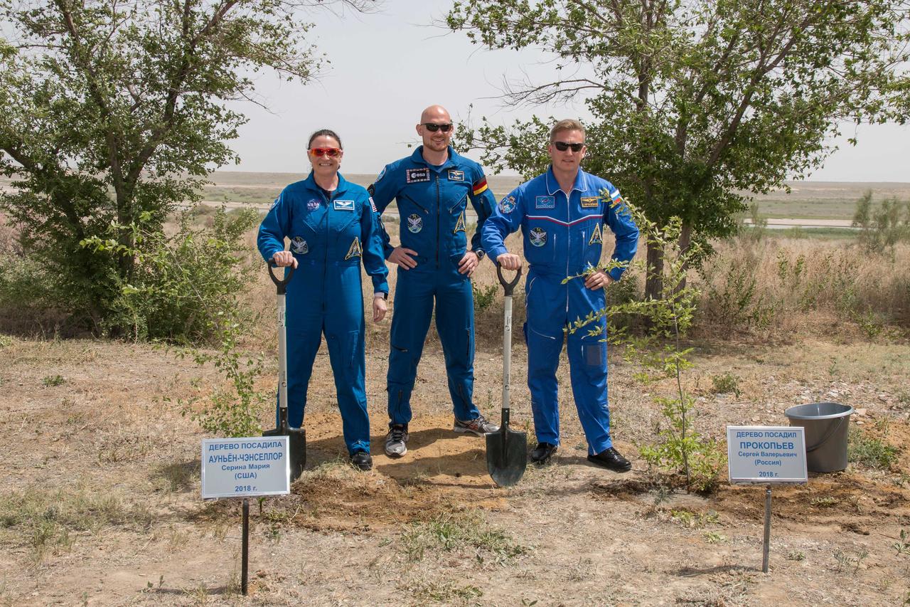 jsc2018e050832 - At the Cosmonaut Hotel crew quarters in Baikonur, Kazakhstan, Expedition 56 crewmembers Serena Aunon-Chancellor of NASA (left), Alexander Gerst of the European Space Agency (center) and Sergey Prokopyev of Roscosmos (right) pose for pictures May 29 after Aunon-Chancellor and Prokopyev planted trees bearing their names in traditional pre-launch activities for first-time fliers. Aunon-Chancellor, Prokopyev and Gerst will launch June 6 from the Baikonur Cosmodrome in Kazakhstan on the Soyuz MS-09 spacecraft for a six-month mission on the International Space Station...NASA/Victor Zelentsov.