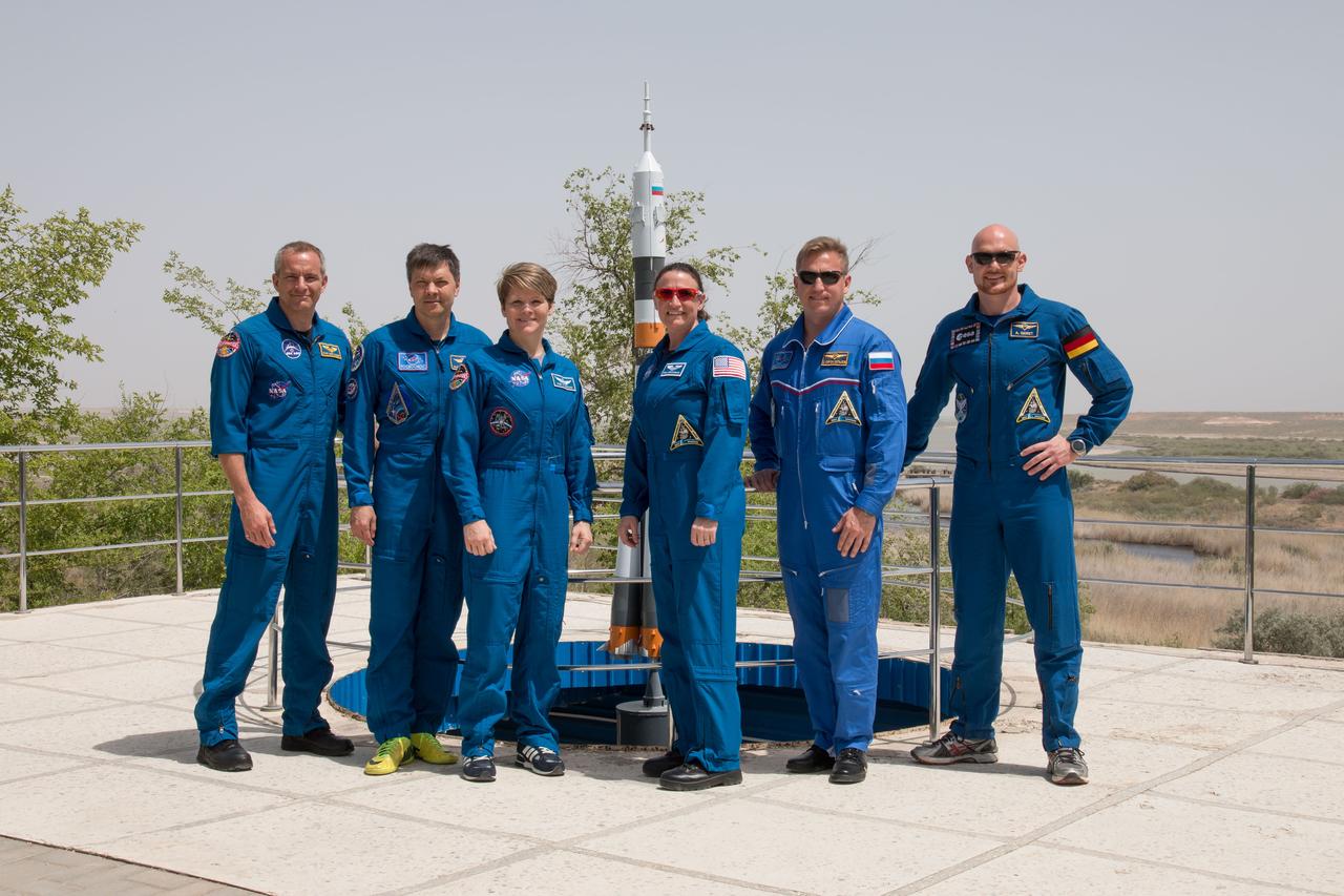 jsc2018e050835 - At the Cosmonaut Hotel crew quarters in Baikonur, Kazakhstan, the Expedition 56 backup and prime crewmembers pose for pictures May 29 in front of a model of a Soyuz rocket. From left to right are the backup crewmembers, David Saint-Jacques of the Canadian Space Agency, Oleg Kononenko of Roscosmos and Anne McClain of NASA and the prime crew, Serena Aunon-Chancellor of NASA, Sergey Prokopyev of Roscosmos and Alexander Gerst of the European Space Agency. Aunon-Chancellor, Prokopyev and Gerst will launch June 6 from the Baikonur Cosmodrome in Kazakhstan on the Soyuz MS-09 spacecraft for a six-month mission on the International Space Station...NASA/Victor Zelentsov.
