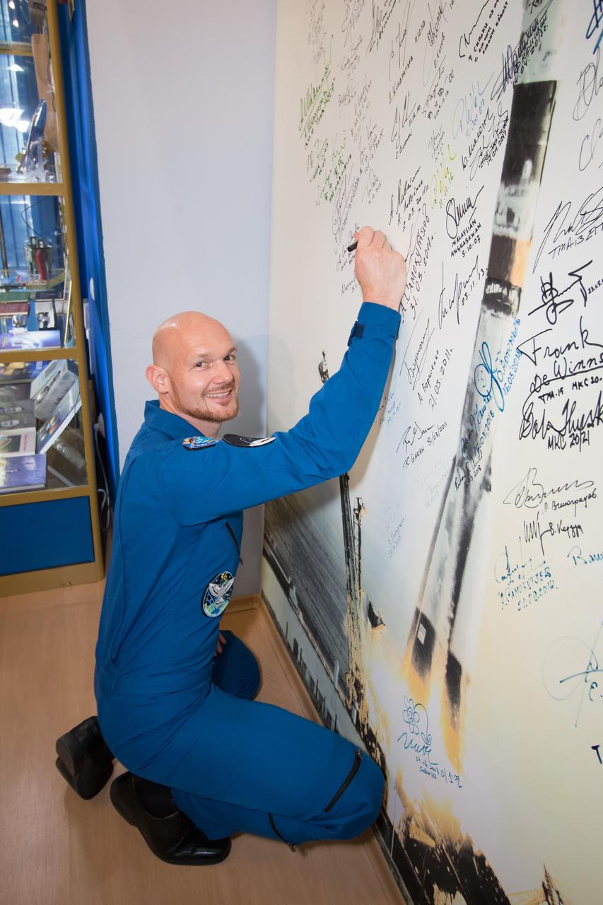 jsc2018e051934 - In the Korolev Museum at the Baikonur Cosmodrome in Kazakhstan, Expedition 56 crewmember Alexander Gerst of the European Space Agency signs a wall mural May 31 during traditional pre-launch activities. Gerst, Serena Aunon-Chancellor of NASA and Sergey Prokopyev of Roscosmos will launch June 6 in the Soyuz MS-09 spacecraft for a six-month mission on the International Space Station. ..NASA/Victor Zelentsov.