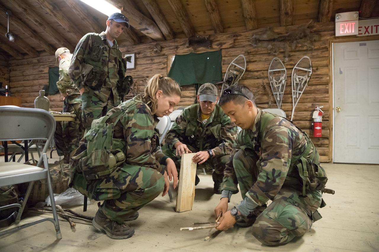 jsc2018e052122 (May 30, 2018) --- (From left) 2017 NASA astronaut candidate Jonny Kim prepares for his next assignment as Canadian Space Agency astronaut candidates Joshua Kutryk (standing), Jennifer Sidey-Gibbons, and NASA astronaut candidate Bob Hines look on during wilderness survival training at the U.S. Navy’s Survival, Evasion, Resistance, and Escape School in Brunswick, Maine. Photo Credit: (NASA/Josh Valcarcel)