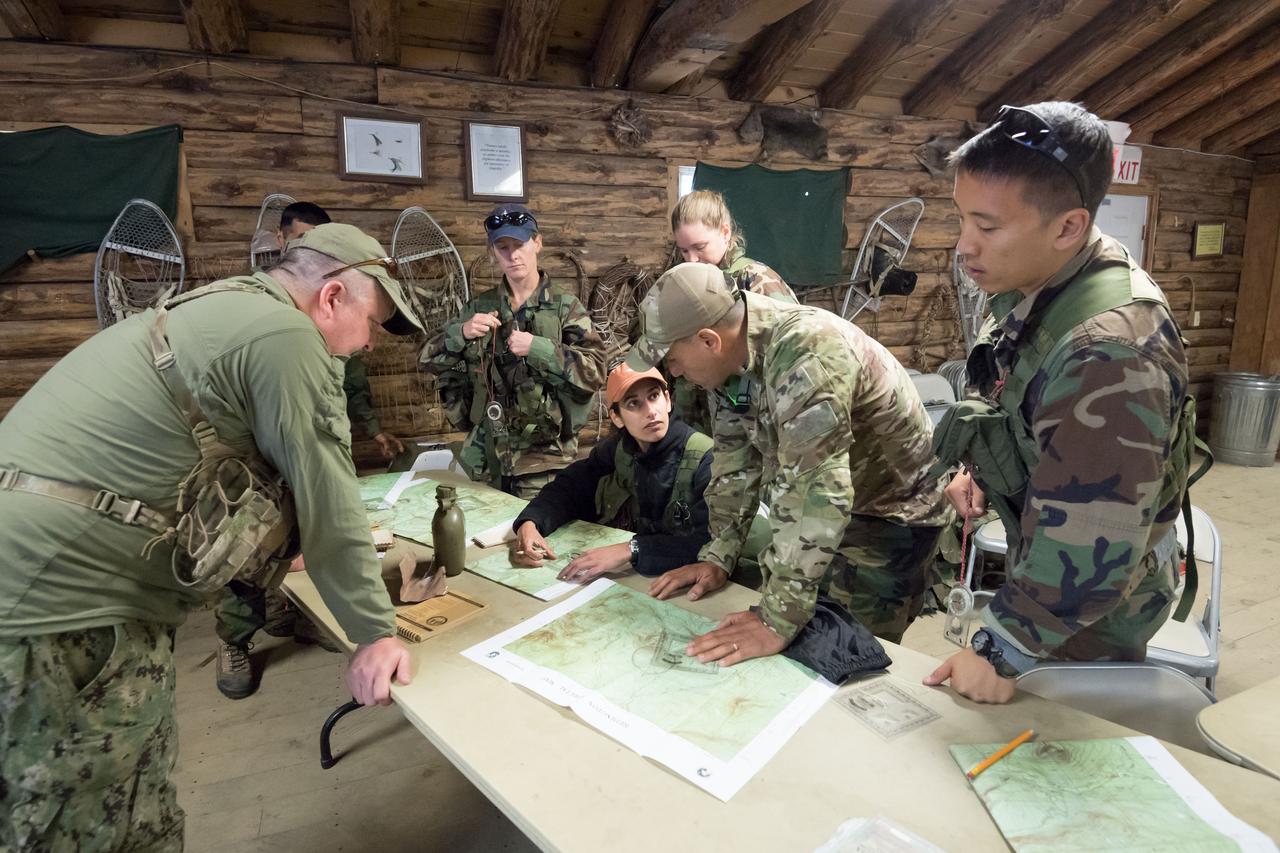jsc2018e052124 (May 30, 2018) --- 2017 NASA astronaut candidates Jasmin Moghbeli and Frank Rubio discuss their next plan of action while fellow astronaut candidates and their instructor study their topographical maps during wilderness survival training at the U.S. Navy’s Survival, Evasion, Resistance, and Escape School in Brunswick, Maine. Photo Credit: (NASA/Josh Valcarcel)