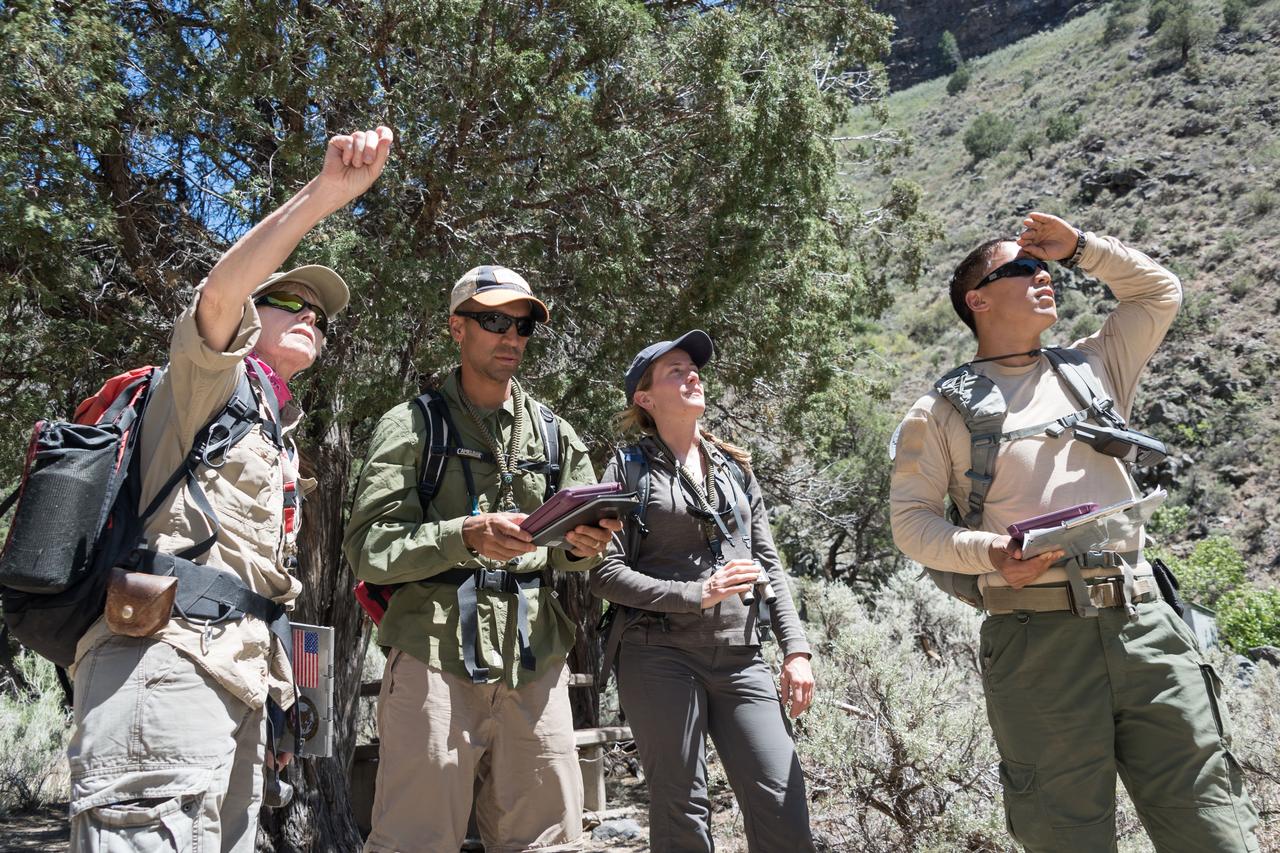 jsc2018e060219 (06/19/2018) --- 2017 NASA astronaut candidates Raja Chari, Loral O’Hara, and Jonny Kim stop for guidance by their field guide during earth and planetary science training in Rio Grande del Norte National Monument Upper Gorge Area near Questa, N.M. Photo Credit: (NASA/Norah Moran)