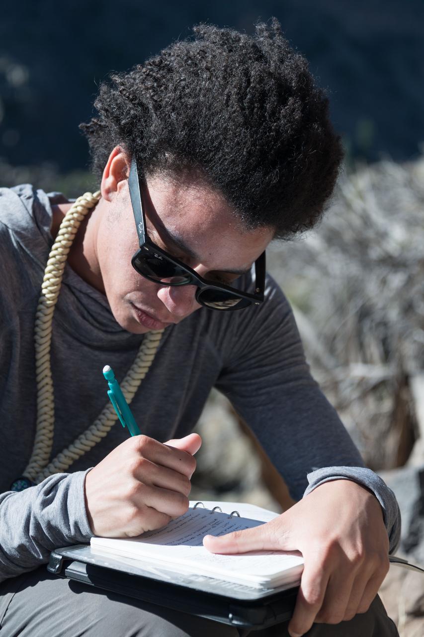 jsc2018e060282 (06/19/2018) --- 2017 NASA astronaut candidate Jessica Watkins taking notes during earth and planetary science training in Rio Grande del Norte National Monument Upper Gorge Area near Questa, N.M. Photo Credit: (NASA/Norah Moran)