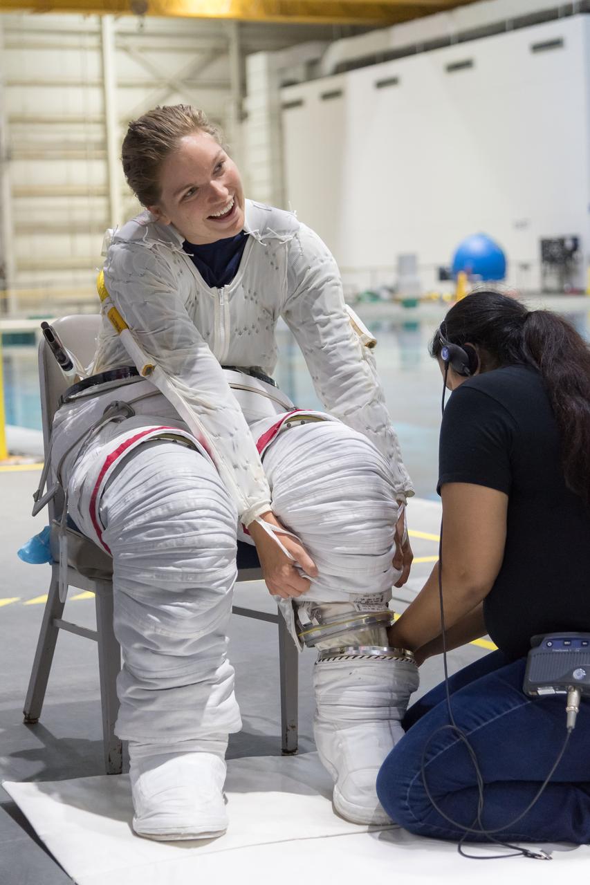 jsc2018e065018 (July 19, 2018) --- Canadian Space Agency astronaut candidate Jennifer Sidey-Gibbons in a Liquid Cooling and Ventilation Garment and being helped into a spacesuit prior to underwater spacewalk training at NASA Johnson Space Center’s Neutral Buoyancy Laboratory in Houston. The cooling garment distributes water throughout to help keep her cool while training underwater. Photo Credit: (NASA/Josh Valcarcel)