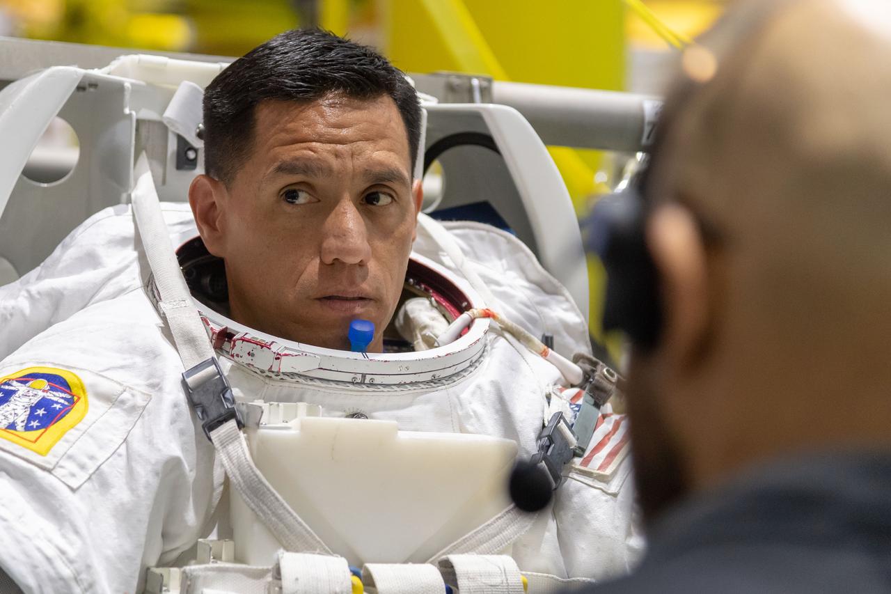 jsc2018e065023 (July 19, 2018) --- 2017 NASA astronaut candidate Frank Rubio is being helped into a spacesuit prior to underwater spacewalk training at NASA Johnson Space Center’s Neutral Buoyancy Laboratory in Houston. Photo Credit: (NASA/Josh Valcarcel)