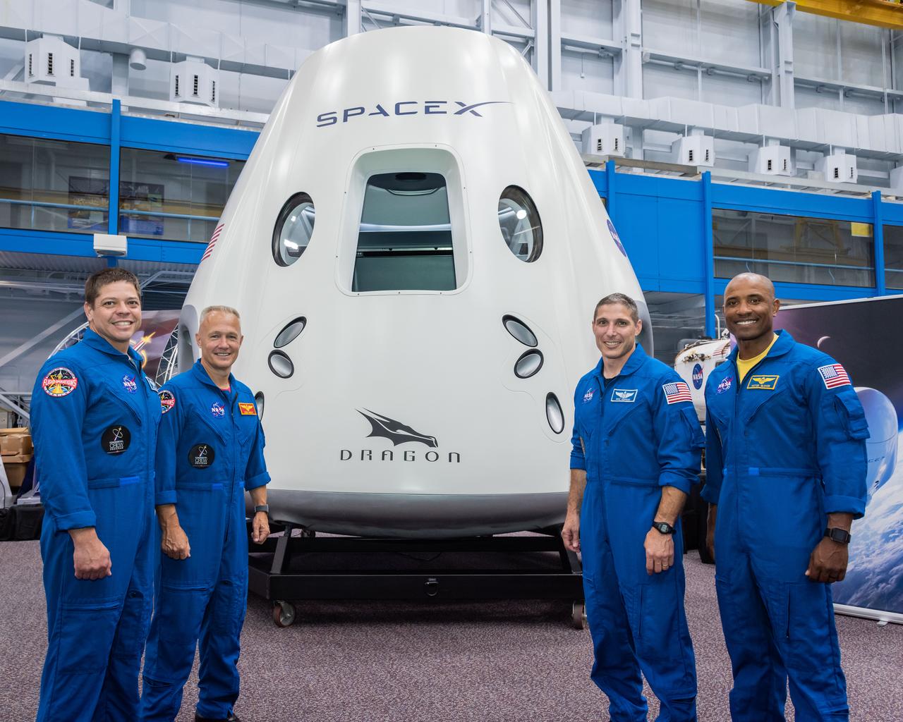 jsc2018e067954 (Aug. 2, 2018) --- NASA astronauts (from left) Bob Behnken, Doug Hurley, Mike Hopkins and Victor Glover pose for a portrait in front of the SpaceX Dragon Commercial Crew vehicle mock up at NASA's Johnson Space Center in Houston, Texas.
