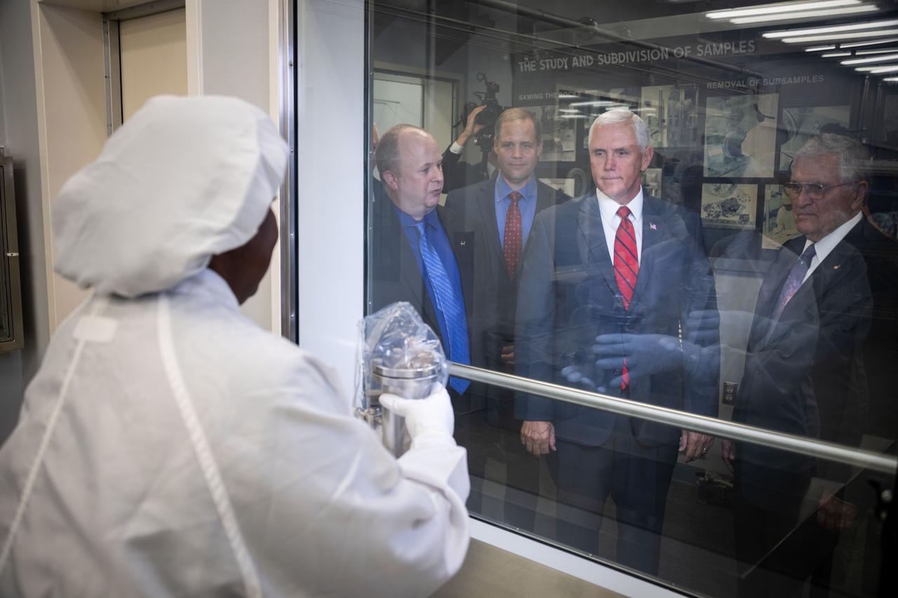jsc2018e076652 (Aug. 23, 2018) --- Vice President Mike Pence visited NASA’s Johnson Space Center in Houston on Aug. 23, 2018, to discuss the future of space exploration and other elements of human spaceflight. During his trip to the Johnson Space Center, the Vice President also toured the laboratory housing the moon rocks retrieved during the Apollo program’s lunar missions and extraterrestrial samples from other uncrewed sample return missions. Apollo Lunar Sample Principle Scientist Andrea Mosie held a lunar sample up for inspection by the Vice President, who was joined in the viewing room behind protective glass by Apollo Lunar Sample Curator Ryan Ziegler.