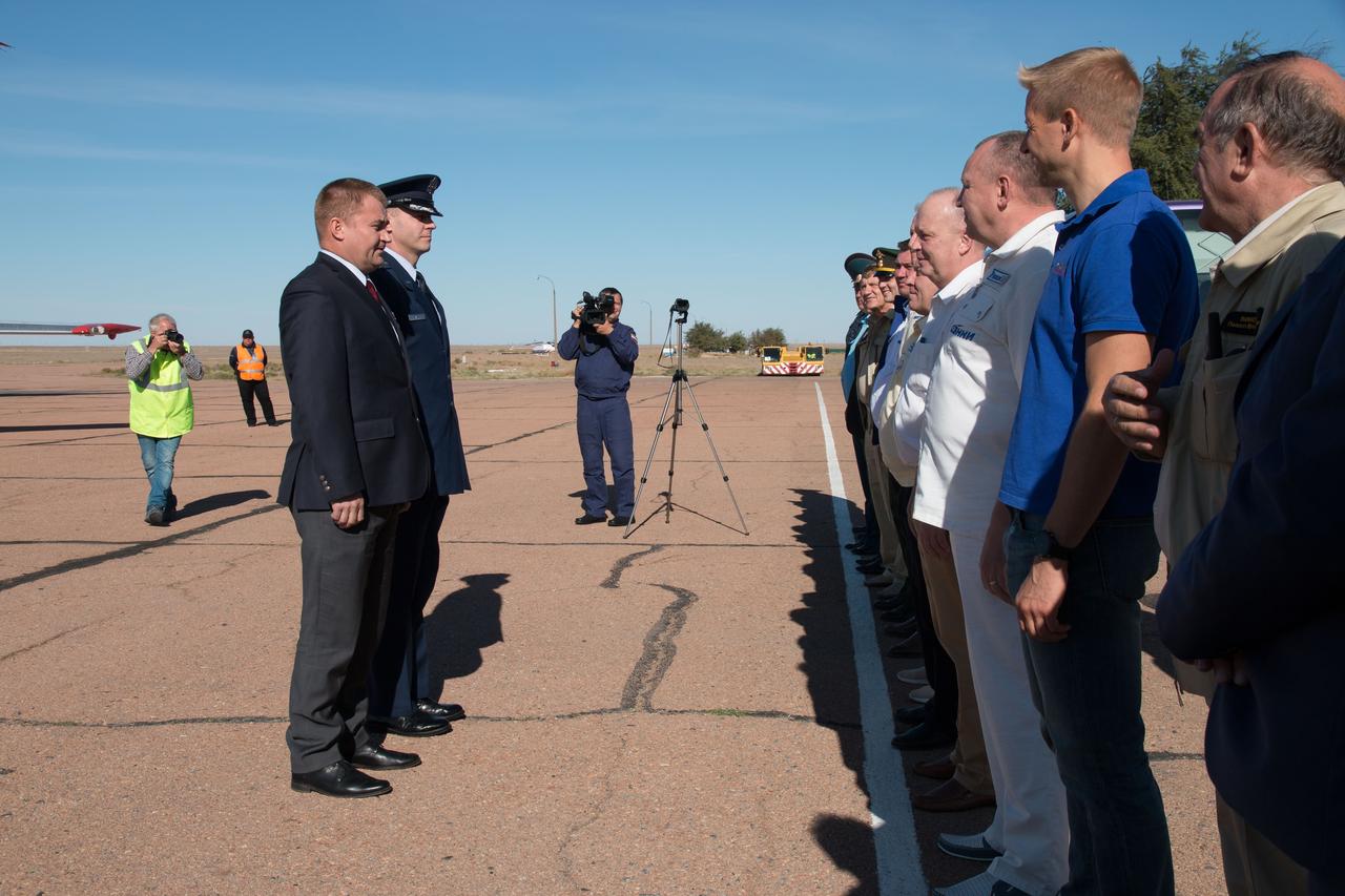 jsc2018e084339 - Expedition 57 crewmembers Alexey Ovchinin of Roscosmos (foreground) and Nick Hague of NASA report to Russian space officials Sept. 25 upon arriving at their launch site in Baikonur, Kazakhstan for final pre-launch training after a flight from their training base in Star City, Russia. Hague and Ovchinin will launch Oct. 11 from the Baikonur Cosmodrome in Kazakhstan on the Soyuz MS-10 spacecraft for a six-month mission on the International Space Station..NASA/Victor Zelentsov.