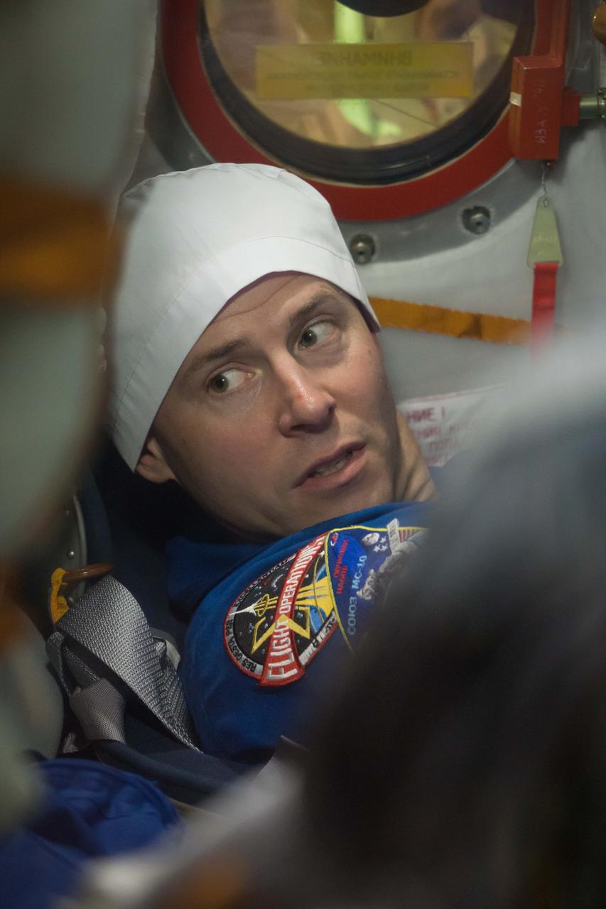 jsc2018e084484 - At the Baikonur Cosmodrome in Kazakhstan, Expedition 57 crewmember Nick Hague is seen through a window on the Soyuz MS-10 spacecraft as he conducted a fit check dress rehearsal Sept. 26. Hague and Alexey Ovchinin of Roscosmos will launch Oct. 11 in the Soyuz MS-10 from the Baikonur Cosmodrome for a six-month mission on the International Space Station...NASA/Victor Zelentsov.