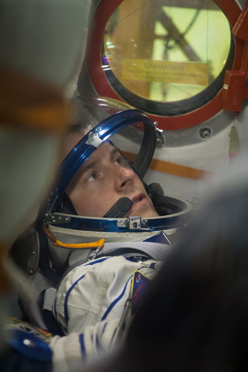 jsc2018e084495 - At the Baikonur Cosmodrome in Kazakhstan, Expedition 57 crewmember Nick Hague is seen through a window on the Soyuz MS-10 spacecraft as he conducted a fit check dress rehearsal Sept. 26. Hague and Alexey Ovchinin of Roscosmos will launch Oct. 11 in the Soyuz MS-10 from the Baikonur Cosmodrome for a six-month mission on the International Space Station...NASA/Victor Zelentsov.