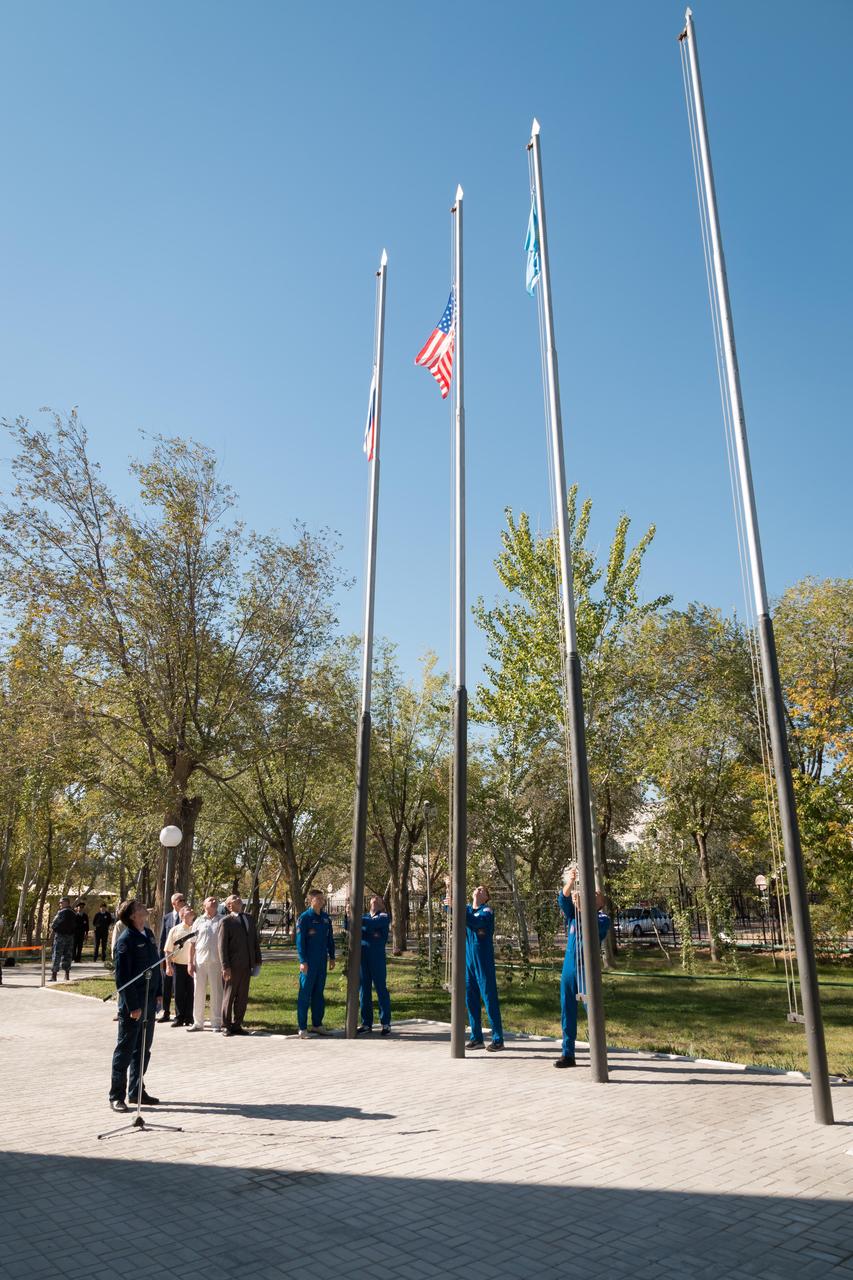 jsc2018e084635 - At their Cosmonaut Hotel crew quarters in Baikonur, Kazakhstan, the Expedition 57 prime and backup crewmembers raise the flags of Russia, the United States and Kazakhstan Sept. 27 in traditional pre-launch ceremonies. Alexey Ovchinin of Roscosmos and Nick Hague of NASA will launch Oct. 11 on the Soyuz MS-10 spacecraft from the Baikonur Cosmodrome in Kazakhstan for a six-month mission on the International Space Station...NASA/Victor Zelentsov.