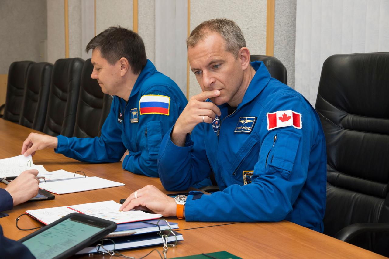 jsc2018e085892 (Oct. 3, 2018) --- Expedition 57 backup crew members Oleg Kononenko of Roscosmos, left, and David Saint-Jacques of the Canadian Space Agency, right, review training documents with a Gagarin Cosmonaut Training Center instructor as they prepare for their upcoming launch, Wednesday, Oct. 3, 2018 at the Cosmonaut Hotel in Baikonur, Kazakhstan. Alexey Ovchinin of Roscosmos and Nick Hague of NASA are scheduled to launch on Oct. 11 onboard the Soyuz MS-10 spacecraft from the Baikonur Cosmodrome in Kazakhstan for a six-month mission on the International Space Station. Photo Credit: (NASA/Victor Zelentsov)