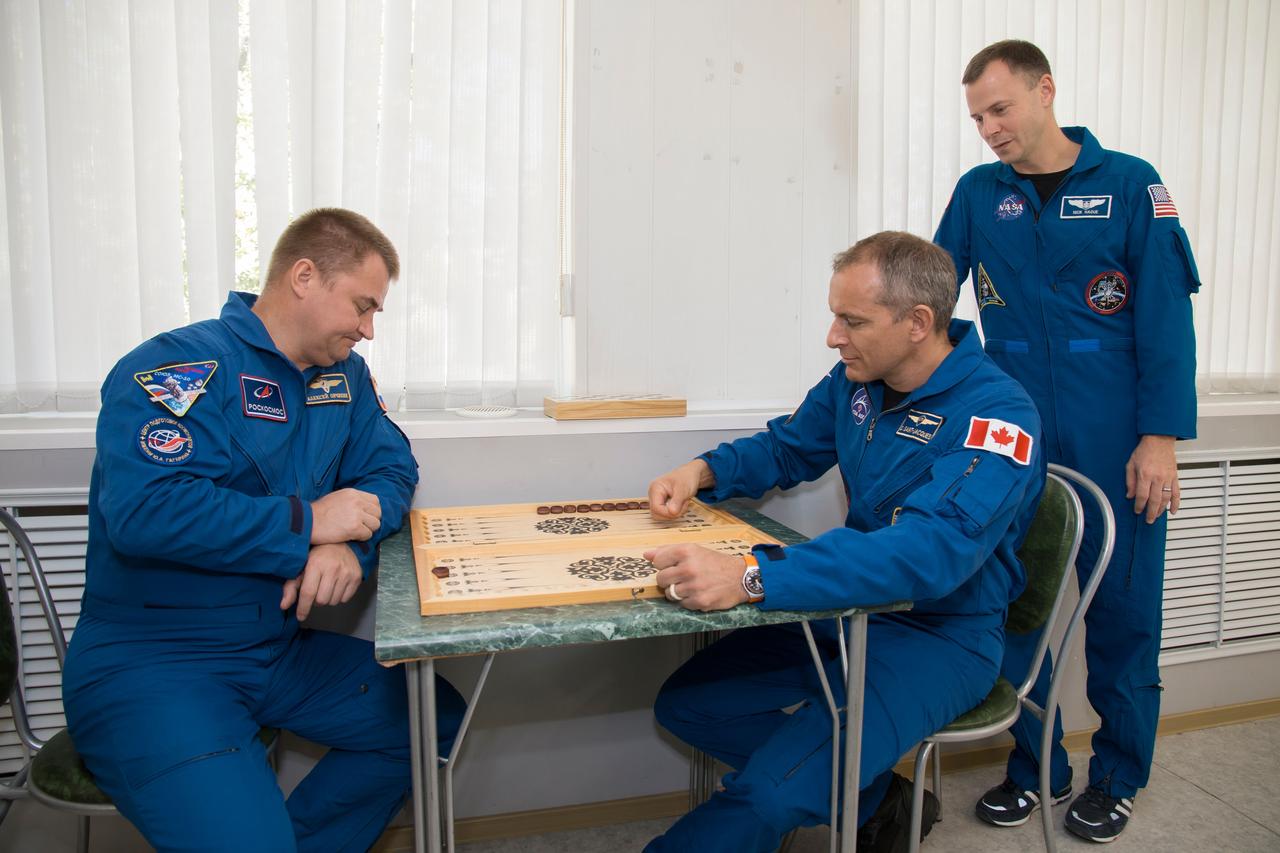 jsc2018e085895 (Oct. 3, 2018) --- Expedition 57 prime crew member Alexey Ovchinin of Roscosmos, left, plays backgammon with backup crew member David Saint-Jacques of the Canadian Space Agency as prime crew member Nick Hague of NASA looks on during the traditional pre-launch ceremonies, Wednesday, Oct. 3, 2018 at the Cosmonaut Hotel in Baikonur, Kazakhstan. Ovchinin and Hague are scheduled to launch on Oct. 11 onboard the Soyuz MS-10 spacecraft from the Baikonur Cosmodrome in Kazakhstan for a six-month mission on the International Space Station. Photo Credit: (NASA/Victor Zelentsov)