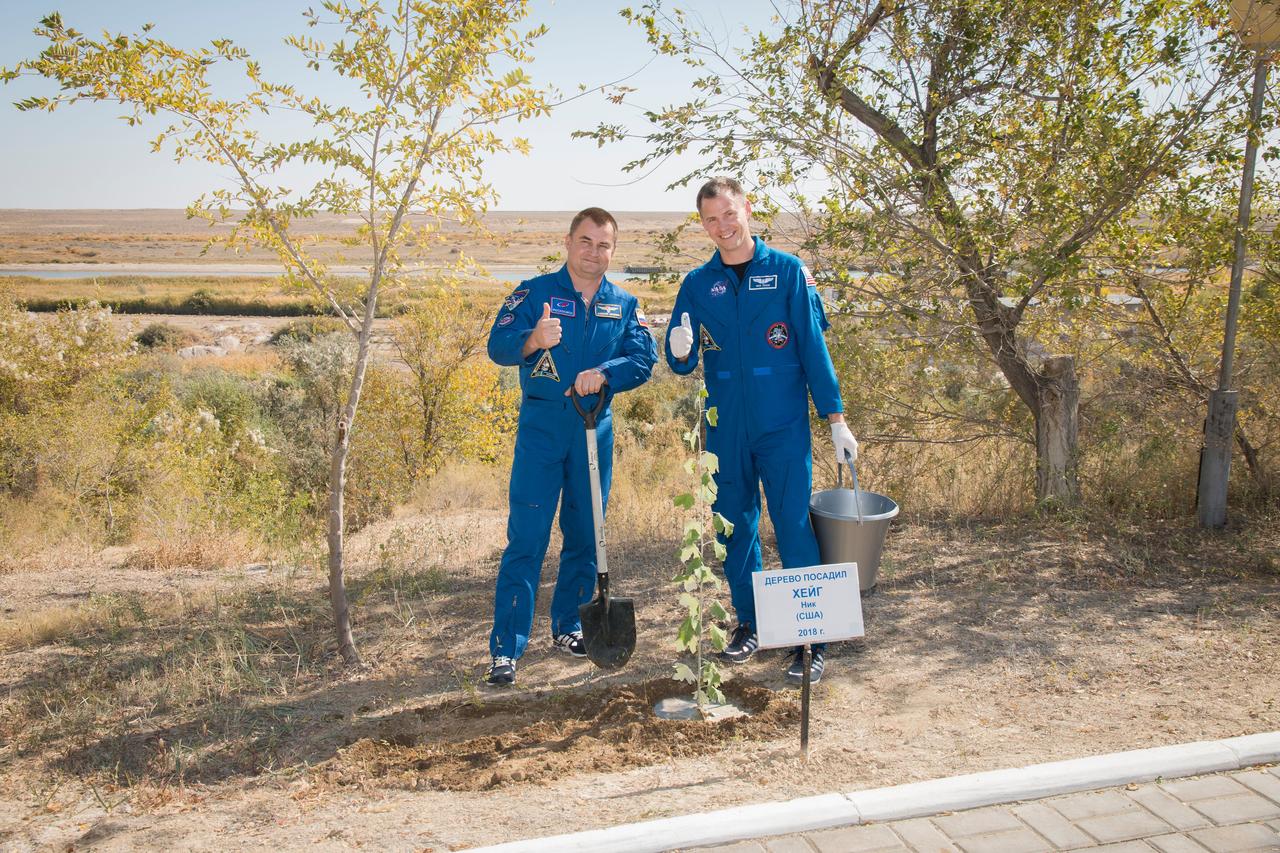 jsc2018e085904 (Oct. 3, 2018) --- Expedition 57 crew members Alexey Ovchinin of Roscosmos, left, and Nick Hauge of NASA, right, pose for a picture after Hague planted a tree bearing his name as part of the traditional pre-launch activities for first-time flieers, Wednesday, Oct. 3, 2018 at the Cosmonaut Hotel in Baikonur, Kazakhstan. Hague and Ovchinin are scheduled to launch on Oct. 11 onboard the Soyuz MS-10 spacecraft from the Baikonur Cosmodrome in Kazakhstan for a six-month mission on the International Space Station. Photo Credit: (NASA/Victor Zelentsov)