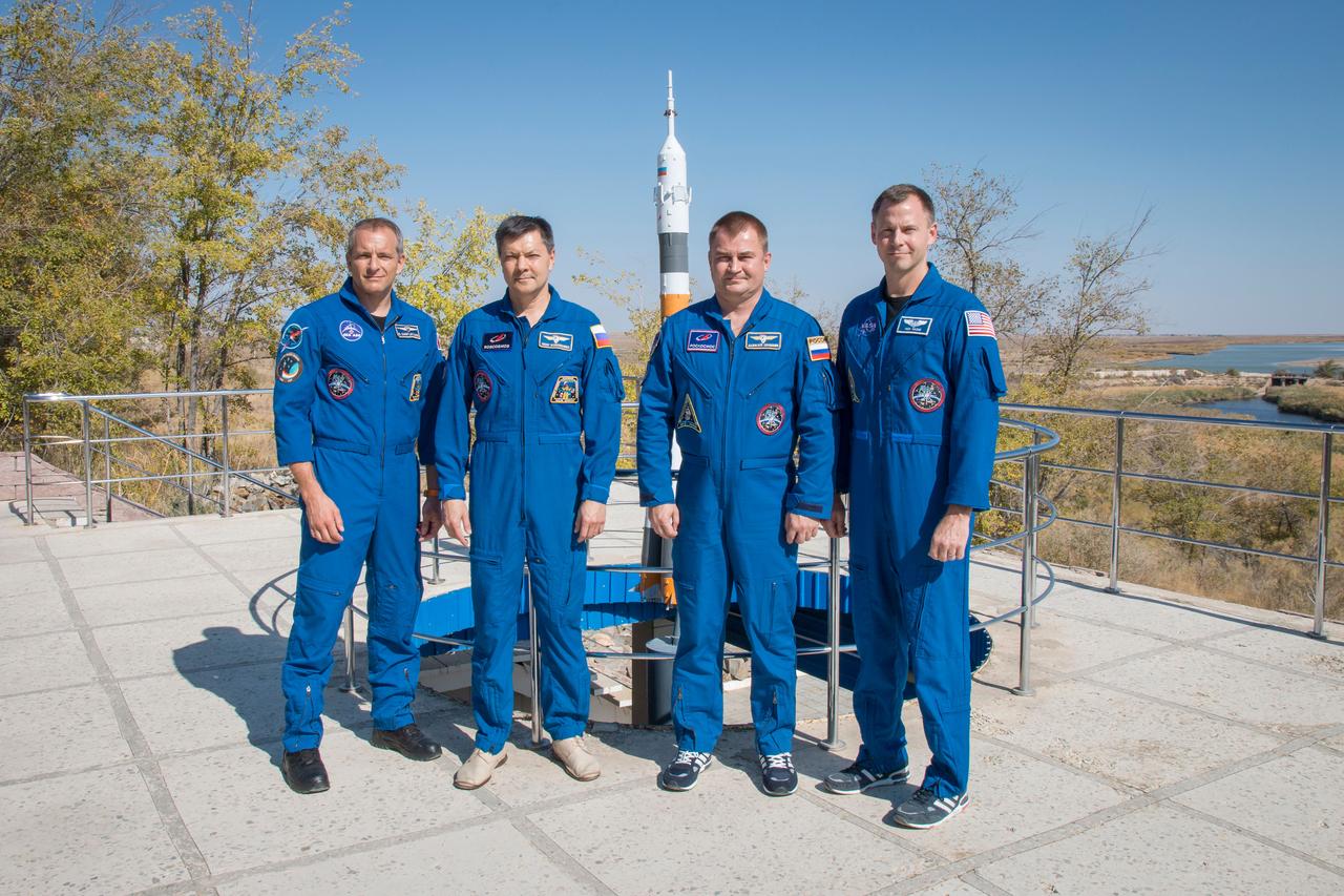 jsc2018e085907 (Oct. 3, 2018) --- Expedition 57 backup and prime crew members pose for pictures in front of a model of a Soyuz rocket, Wednesday, Oct. 3, 2018 at the Cosmonaut Hotel crew quarters in Baikonur, Kazakhstan. From left are backup crew members David Saint-Jacques of the Canadian Space Agency and Oleg Kononenko of Roscosmos and prime crew members Alexey Ovchinin of Roscosmos and Nick Hague of NASA. Ovchinin and Hague are scheduled to launch on Oct. 11 onboard the Soyuz MS-10 spacecraft from the Baikonur Cosmodrome in Kazakhstan for a six-month mission on the International Space Station. Photo Credit: (NASA/Victor Zelentsov)