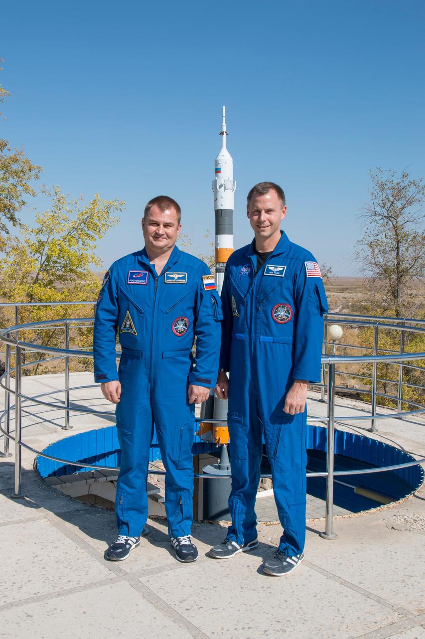 jsc2018e085908 (Oct. 3, 2018) --- Expedition 57 prime crew members Alexey Ovchinin of Roscosmos, left, and Nick Hague of NASA, right, pose for pictures in front of a model of a Soyuz rocket, Wednesday, Oct. 3, 2018 at the Cosmonaut Hotel crew quarters in Baikonur, Kazakhstan. Ovchinin and Hague are scheduled to launch on Oct. 11 onboard the Soyuz MS-10 spacecraft from the Baikonur Cosmodrome in Kazakhstan for a six-month mission on the International Space Station. Photo Credit: (NASA/Victor Zelentsov)