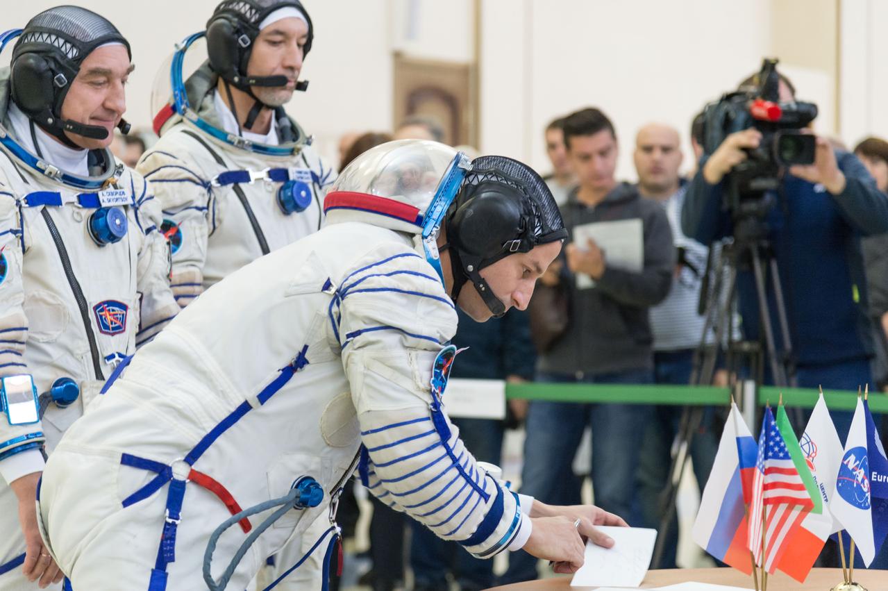 jsc2018e094958 - At the Gagarin Cosmonaut Training Center in Star City, Russia, Expedition 58 backup crewmember Drew Morgan of NASA signs in for qualification exams Nov. 13 as his crewmates, Alexander Skvortsov of Roscosmos (left) and Luca Parmitano of the European Space Agency (right) look on. They are the backups to the prime crew, Oleg Kononenko of Roscosmos, Anne McClain of NASA and David Saint-Jacques of the Canadian Space Agency, who will launch Dec. 3 on the Soyuz MS-11 spacecraft from the Baikonur Cosmodrome in Kazakhstan for a six-and-a-half month mission on the International Space Station...NASA/Sarah Volkman.