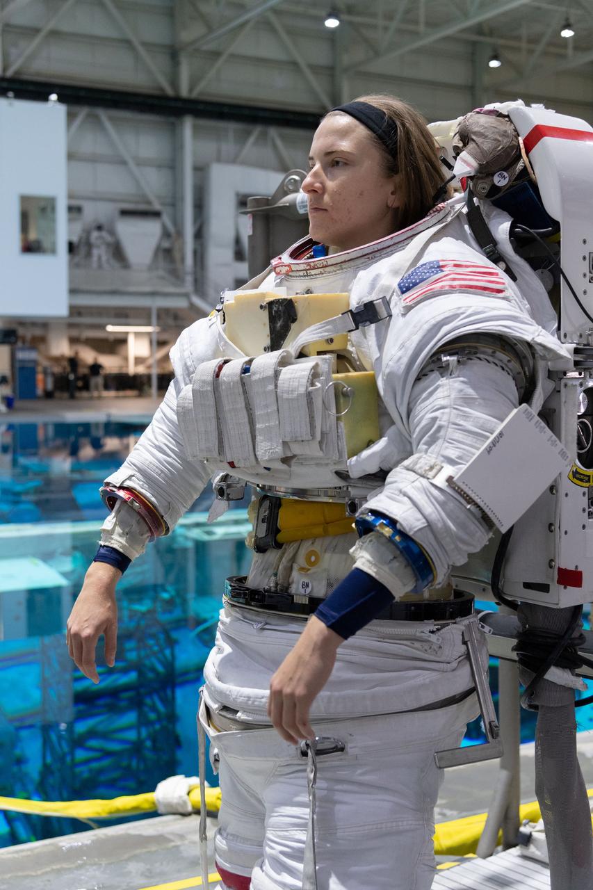 jsc2018e095906 (November 7, 2018) --- 2017 NASA astronaut candidate Kayla Barron is helped into a spacesuit prior to underwater spacewalk training at NASA Johnson Space Center’s Neutral Buoyancy Laboratory in Houston. Photo Credit: (NASA/Robert Markowitz)