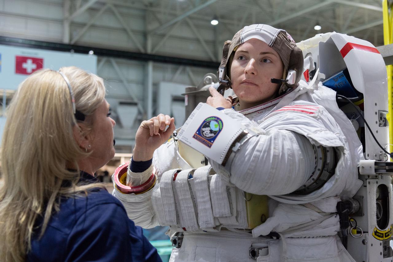 jsc2018e095914 (November 7, 2018) --- 2017 NASA astronaut candidate Kayla Barron is helped into a spacesuit prior to underwater spacewalk training at NASA Johnson Space Center’s Neutral Buoyancy Laboratory in Houston. Photo Credit: (NASA/Robert Markowitz)