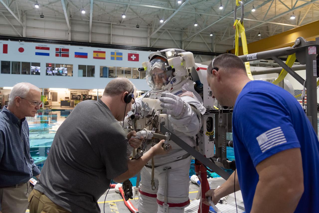 jsc2018e096678 (November 16, 2018) --- 2017 NASA astronaut candidate Raja Chari is helped into a spacesuit prior to underwater spacewalk training at NASA Johnson Space Center’s Neutral Buoyancy Laboratory in Houston. Photo Credit: (NASA/Robert Markowitz)