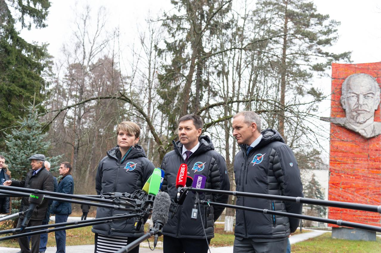 jsc2018e097267 - With the statue of Vladimir Lenin serving as a backdrop, Expedition 58 crewmembers Anne McClain of NASA (left), Oleg Kononenko of Roscosmos (center) and David Saint-Jacques of the Canadian Space Agency (right) answer reporters’ questions Nov. 19 at the Gagarin Cosmonaut Training Center in Star City, Russia before boarding a plane to fly to their launch site in Baikonur, Kazakhstan. McClain, Kononenko and Saint-Jacques will launch Dec. 3 on the Soyuz MS-11 spacecraft from the Baikonur Cosmodrome in Kazakhstan for a six-and-a-half month mission on the International Space Station. NASA/Sarah Volkman