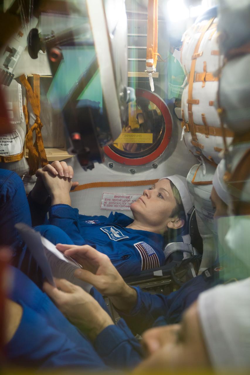 jsc2018e097286 - In the Integration Facility at the Baikonur Cosmodrome in Kazakhstan, Expedition 58 crewmember Anne McClain of NASA runs through procedures in the Soyuz MS-11 spacecraft during a vehicle fit check Nov. 20. McClain, Oleg Kononenko of Roscosmos and David Saint-Jacques of the Canadian Space Agency will launch Dec. 3 on the Soyuz MS-11 spacecraft from the Baikonur Cosmodrome for a six-and-a-half month mission on the International Space Station...NASA/Victor Zelentsov.