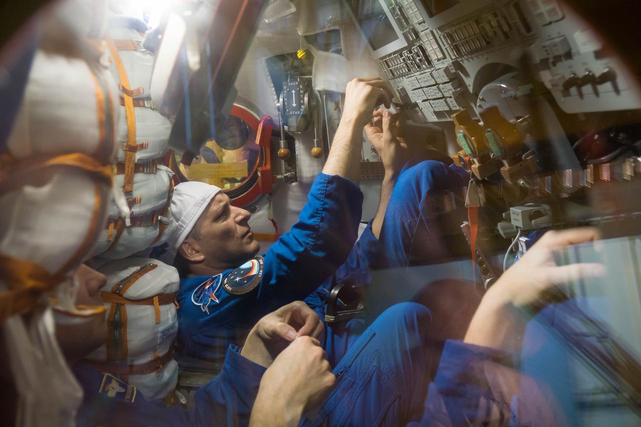jsc2018e097287 - In the Integration Facility at the Baikonur Cosmodrome in Kazakhstan, Expedition 58 crewmember David Saint-Jacques of the Canadian Space Agency runs through procedures in the Soyuz MS-11 spacecraft during a vehicle fit check Nov. 20. Saint-Jacques, Anne McClain of NASA and Oleg Kononenko of Roscosmos will launch Dec. 3 on the Soyuz MS-11 spacecraft from the Baikonur Cosmodrome for a six-and-a-half month mission on the International Space Station...NASA/Victor Zelentsov.