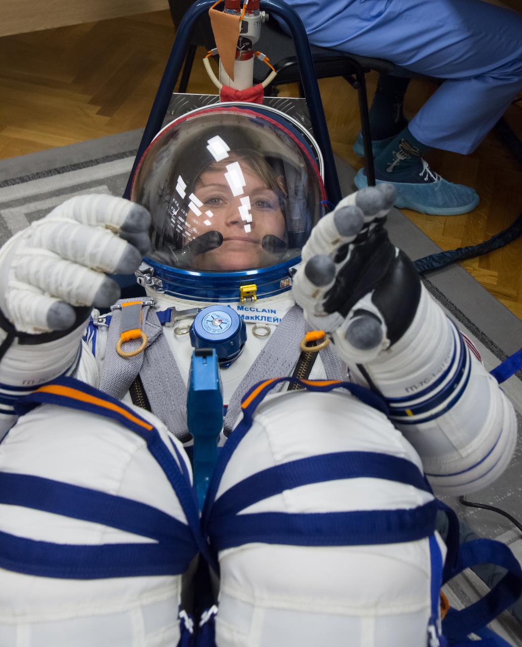 jsc2018e097297 - In the Integration Facility at the Baikonur Cosmodrome in Kazakhstan, Expedition 58 crewmember Anne McClain of NASA conducts a pressure and leak check of her Russian Sokol launch and entry suit Nov. 20. McClain, Oleg Kononenko of Roscosmos and David Saint-Jacques of the Canadian Space Agency will launch Dec. 3 on the Soyuz MS-11 spacecraft from the Baikonur Cosmodrome for a six-and-a-half month mission on the International Space Station...NASA/Victor Zelentsov.