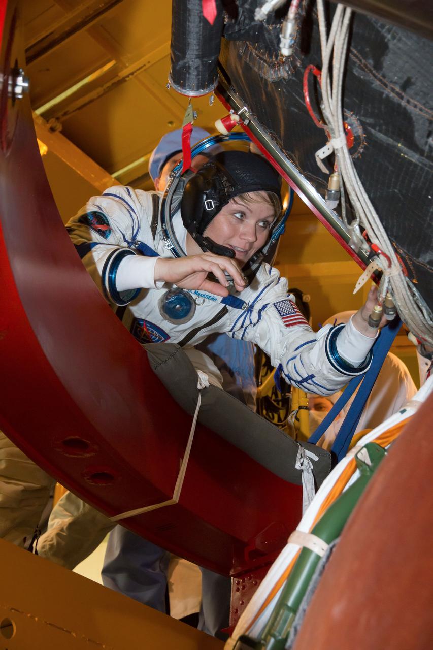 jsc2018e097301 - In the Integration Facility at the Baikonur Cosmodrome in Kazakhstan, Expedition 58 crewmember Anne McClain of NASA climbs on board her Soyuz spacecraft Nov. 20 during a vehicle fit check. McClain, Oleg Kononenko of Roscosmos and David Saint-Jacques of the Canadian Space Agency will launch Dec. 3 on the Soyuz MS-11 spacecraft from the Baikonur Cosmodrome for a six-and-a-half month mission on the International Space Station...NASA/Victor Zelentsov.
