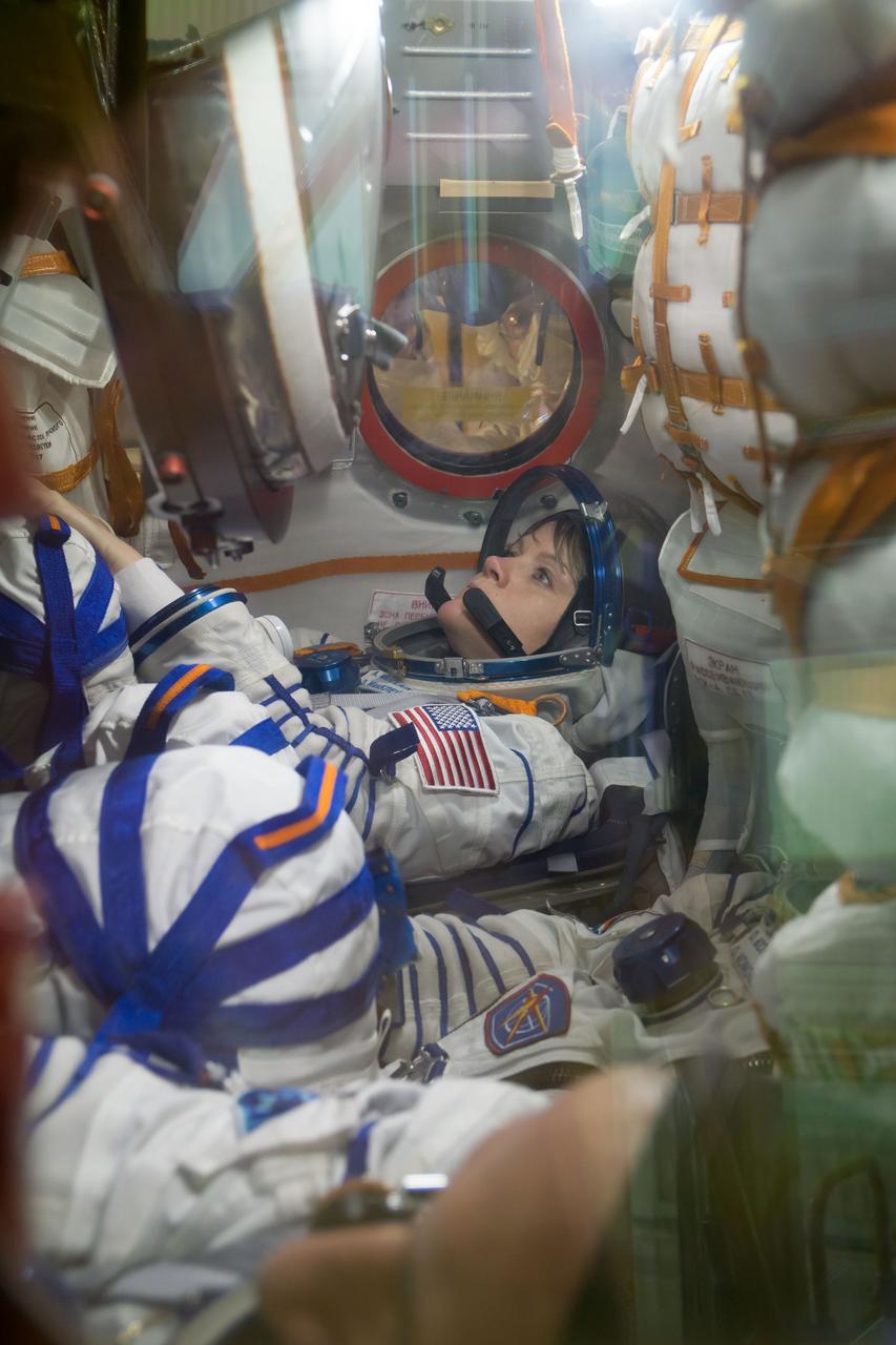 jsc2018e097305 - In the Integration Facility at the Baikonur Cosmodrome in Kazakhstan, Expedition 58 crewmember Anne McClain of NASA runs through procedures in the Soyuz MS-11 spacecraft during a vehicle fit check Nov. 20. McClain, Oleg Kononenko of Roscosmos and David Saint-Jacques of the Canadian Space Agency will launch Dec. 3 on the Soyuz MS-11 spacecraft from the Baikonur Cosmodrome for a six-and-a-half month mission on the International Space Station...NASA/Victor Zelentsov.