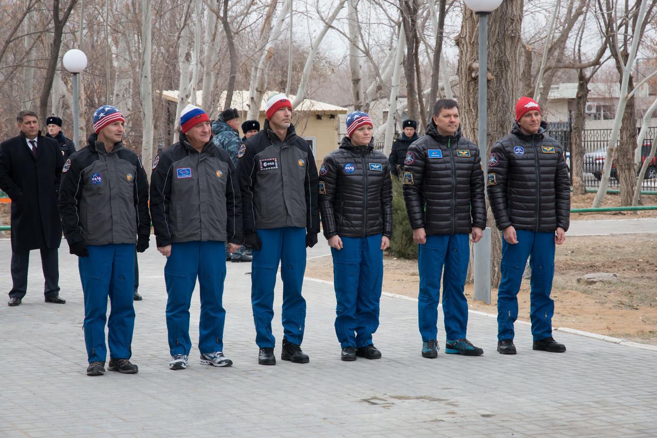 jsc2018e097312 - Outside the Cosmonaut Hotel crew quarters in Baikonur, Kazakhstan, the Expedition 58 prime and backup crewmembers attend a flag-raising ceremony Nov. 21, part of their traditional pre-launch activities. From left to right are backup crewmembers Drew Morgan of NASA, Alexander Skvortsov of Roscosmos and Luca Parmitano of the European Space Agency and prime crewmembers Anne McClain of NASA, Oleg Kononenko of Roscosmos and David Saint-Jacques of the Canadian Space Agency. McClain, Kononenko and Saint-Jacques will launch Dec. 3 on the Soyuz MS-11 spacecraft from the Baikonur Cosmodrome in Kazakhstan for a six-and-a-half month mission on the International Space Station...NASA/Victor Zelentsov.