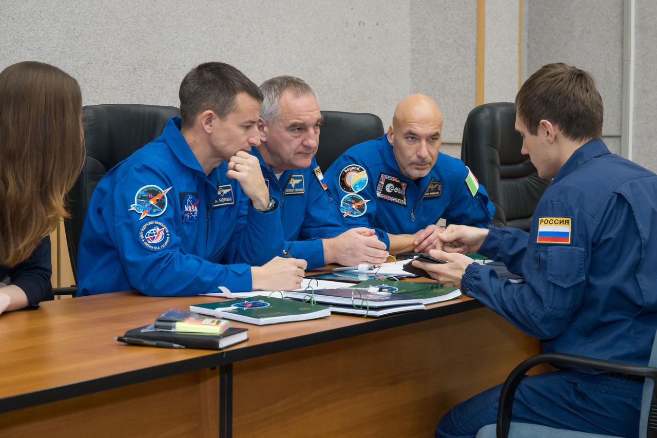 jsc2018e097763 - At their Cosmonaut Hotel crew quarters in Baikonur, Kazakhstan, Expedition 58 backup crewmembers Drew Morgan of NASA (left), Alexander Skvortsov of Roscosmos (center) and Luca Parmitano of the European Space Agency (right) review flight procedures with a training instructor Nov. 27 as part of their pre-launch training. They are the backups to Anne McClain of NASA, Oleg Kononenko of Roscosmos and David Saint-Jacques of the Canadian Space Agency who will launch Dec. 3 on the Soyuz MS-11 spacecraft from the Baikonur Cosmodrome in Kazakhstan for a six-and-a-half month mission on the International Space Station...NASA/Victor Zelentsov.