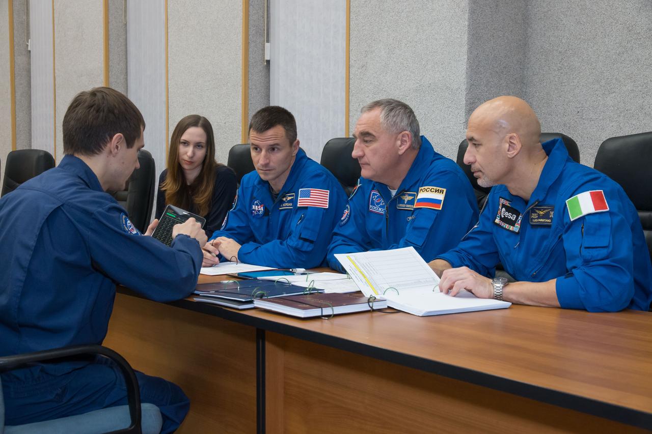 jsc2018e097764 - At their Cosmonaut Hotel crew quarters in Baikonur, Kazakhstan, Expedition 58 backup crewmembers Drew Morgan of NASA (second from left), Alexander Skvortsov of Roscosmos (second from right) and Luca Parmitano of the European Space Agency (right) review flight procedures with a training instructor Nov. 27 as part of their pre-launch training. They are the backups to Anne McClain of NASA, Oleg Kononenko of Roscosmos and David Saint-Jacques of the Canadian Space Agency who will launch Dec. 3 on the Soyuz MS-11 spacecraft from the Baikonur Cosmodrome in Kazakhstan for a six-and-a-half month mission on the International Space Station...NASA/Victor Zelentsov.