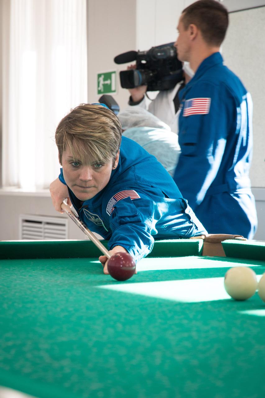 jsc2018e097769 - At her Cosmonaut Hotel crew quarters in Baikonur, Kazakhstan, Expedition 58 crewmember Anne McClain of NASA tries her hand at a game of billiards Nov. 27 during free time from pre-launch training. McClain, David Saint-Jacques of the Canadian Space Agency and Oleg Kononenko of Roscosmos will launch Dec. 3 on the Soyuz MS-11 spacecraft from the Baikonur Cosmodrome in Kazakhstan for a six-and-a-half month mission on the International Space Station...NASA/Victor Zelentsov.