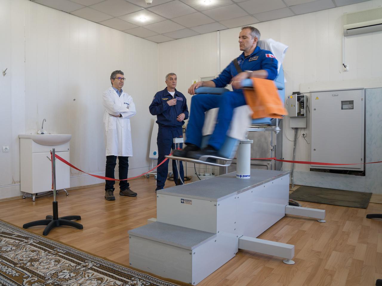 jsc2018e097772 - At the Cosmonaut Hotel crew quarters in Baikonur, Kazakhstan, Expedition 58 crewmember David Saint-Jacques of the Canadian Space Agency conducts vestibular system response training in a spinning chair Nov. 27 as part of pre-launch training. Saint-Jacques, Anne McClain of NASA and Oleg Kononenko of Roscosmos will launch Dec. 3 on the Soyuz MS-11 spacecraft from the Baikonur Cosmodrome in Kazakhstan for a six-and-a-half month mission on the International Space Station...NASA/Victor Zelentsov.