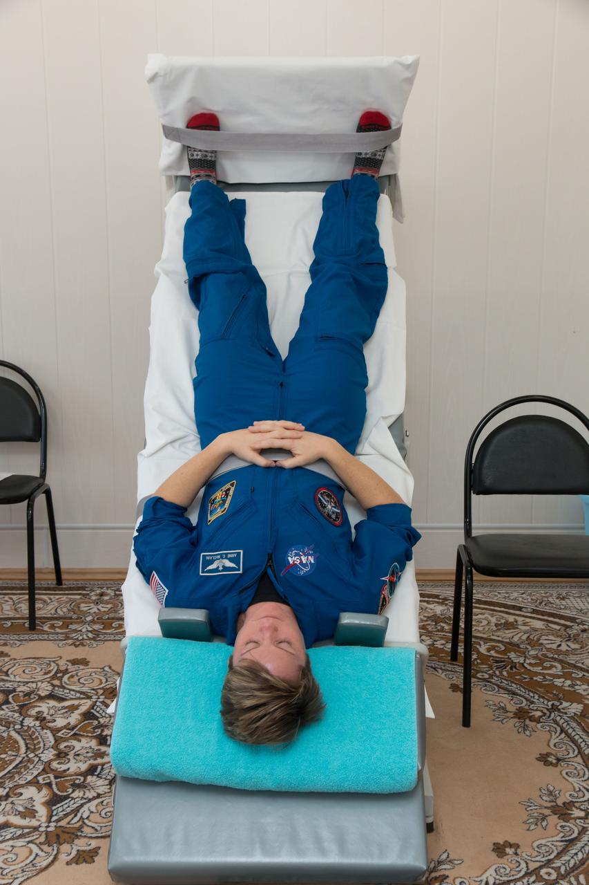 jsc2018e097774 - At the Cosmonaut Hotel crew quarters in Baikonur, Kazakhstan, Expedition 58 crewmember Anne McClain of NASA conducts vestibular system response training on a tilt table Nov. 27 as part of pre-launch training. McClain, David Saint-Jacques of the Canadian Space Agency and Oleg Kononenko of Roscosmos will launch Dec. 3 on the Soyuz MS-11 spacecraft from the Baikonur Cosmodrome in Kazakhstan for a six-and-a-half month mission on the International Space Station...NASA/Victor Zelentsov.