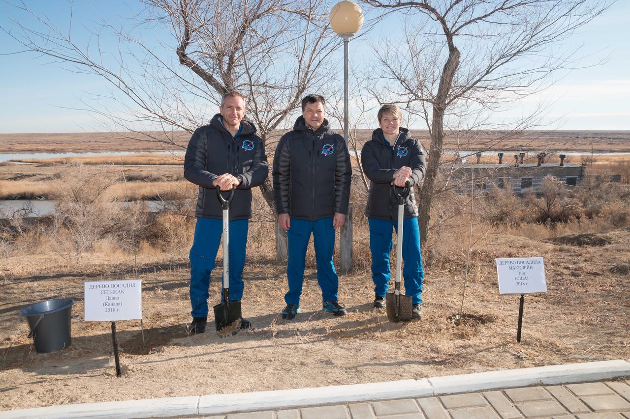 jsc2018e097780 - At the Cosmonaut Hotel crew quarters in Baikonur, Kazakhstan, Expedition 58 crewmembers David Saint-Jacques of the Canadian Space Agency (left), Oleg Kononenko of Roscosmos (center) and Anne McClain of NASA (right) pose for pictures Nov. 27 after Saint-Jacques and McClain planted trees in their names in a traditional pre-launch activity. They will launch Dec. 3 on the Soyuz MS-11 spacecraft from the Baikonur Cosmodrome in Kazakhstan for a six-and-a-half month mission on the International Space Station...NASA/Victor Zelentsov.