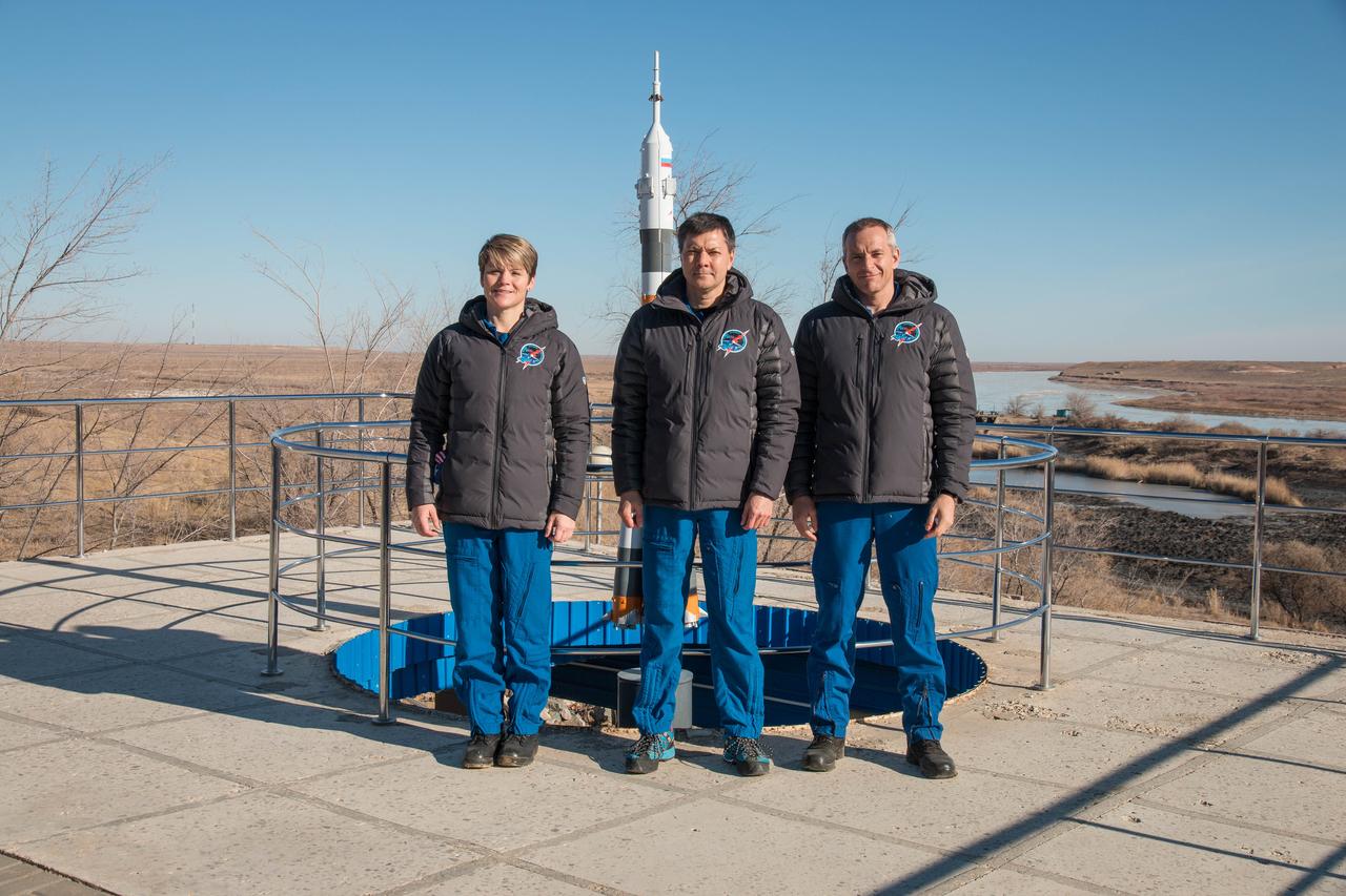 jsc2018e097781 - At their Cosmonaut Hotel crew quarters in Baikonur, Kazakhstan, Expedition 58 crewmembers Anne McClain of NASA (left), Oleg Kononenko of Roscosmos (center) and David Saint-Jacques of the Canadian Space Agency (right) pose for pictures Nov. 27 as part of traditional pre-launch activities. They will launch Dec. 3 on the Soyuz MS-11 spacecraft from the Baikonur Cosmodrome in Kazakhstan for a six-and-a-half month mission on the International Space Station...NASA/Victor Zelentsov.