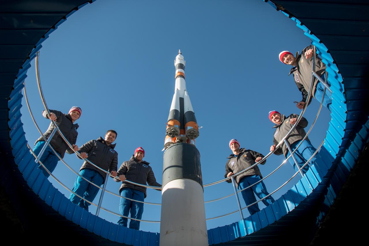 jsc2018e097783 - At their Cosmonaut Hotel crew quarters in Baikonur, Kazakhstan, the Expedition 58 prime and backup crewmembers pose for pictures around a model of a Soyuz rocket Nov. 27 as part of their pre-launch training activities. From left to right are the prime crewmembers, Anne McClain of NASA, Oleg Kononenko of Roscosmos and David Saint-Jacques of the Canadian Space Agency and the backup crew, Drew Morgan of NASA, Alexander Skvortsov of Roscosmos and Luca Parmitano of the European Space Agency. McClain, Saint-Jacques and Kononenko will launch Dec. 3 on the Soyuz MS-11 spacecraft from the Baikonur Cosmodrome in Kazakhstan for a six-and-a-half month mission on the International Space Station...NASA/Victor Zelentsov.
